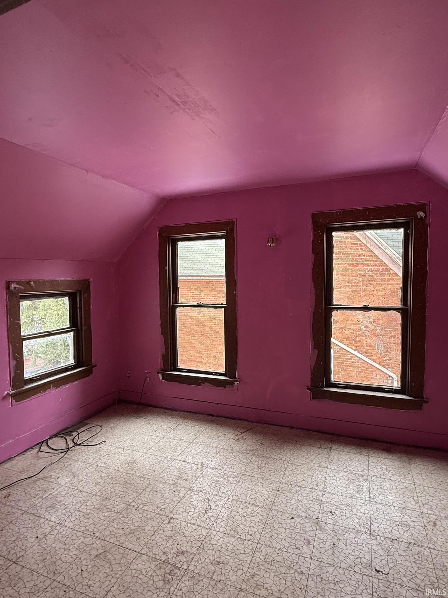 Additional living space featuring vaulted ceiling and tile patterned floors