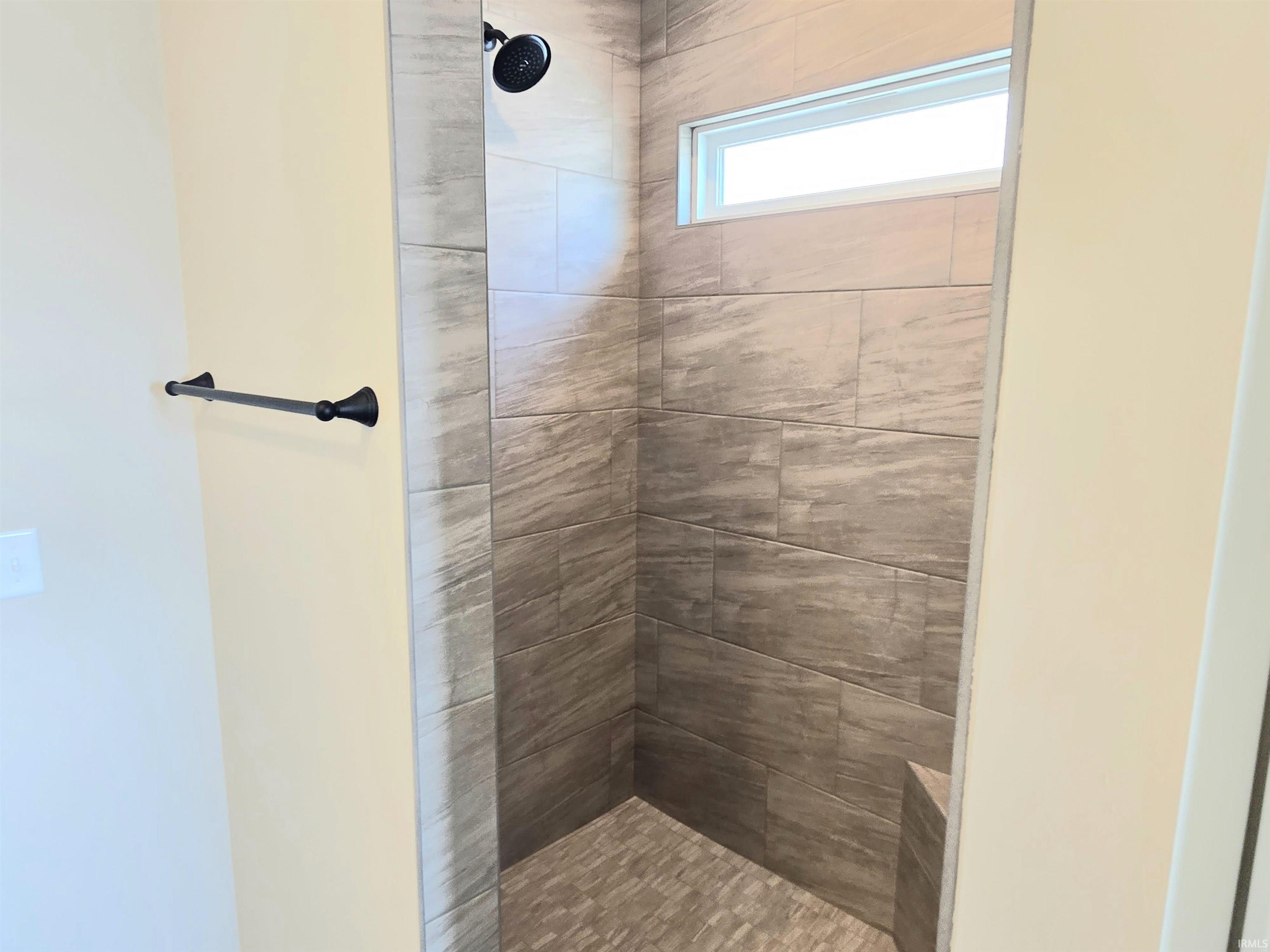 Full bath featuring a tile shower