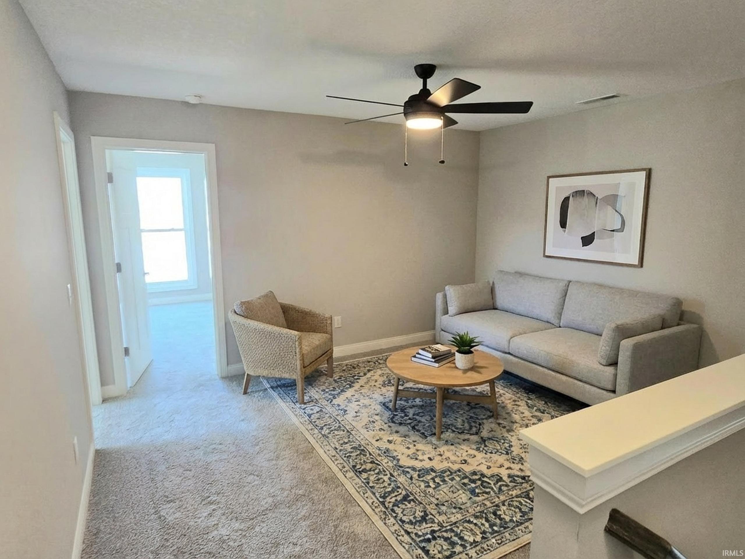 Living room featuring carpet and a ceiling fan