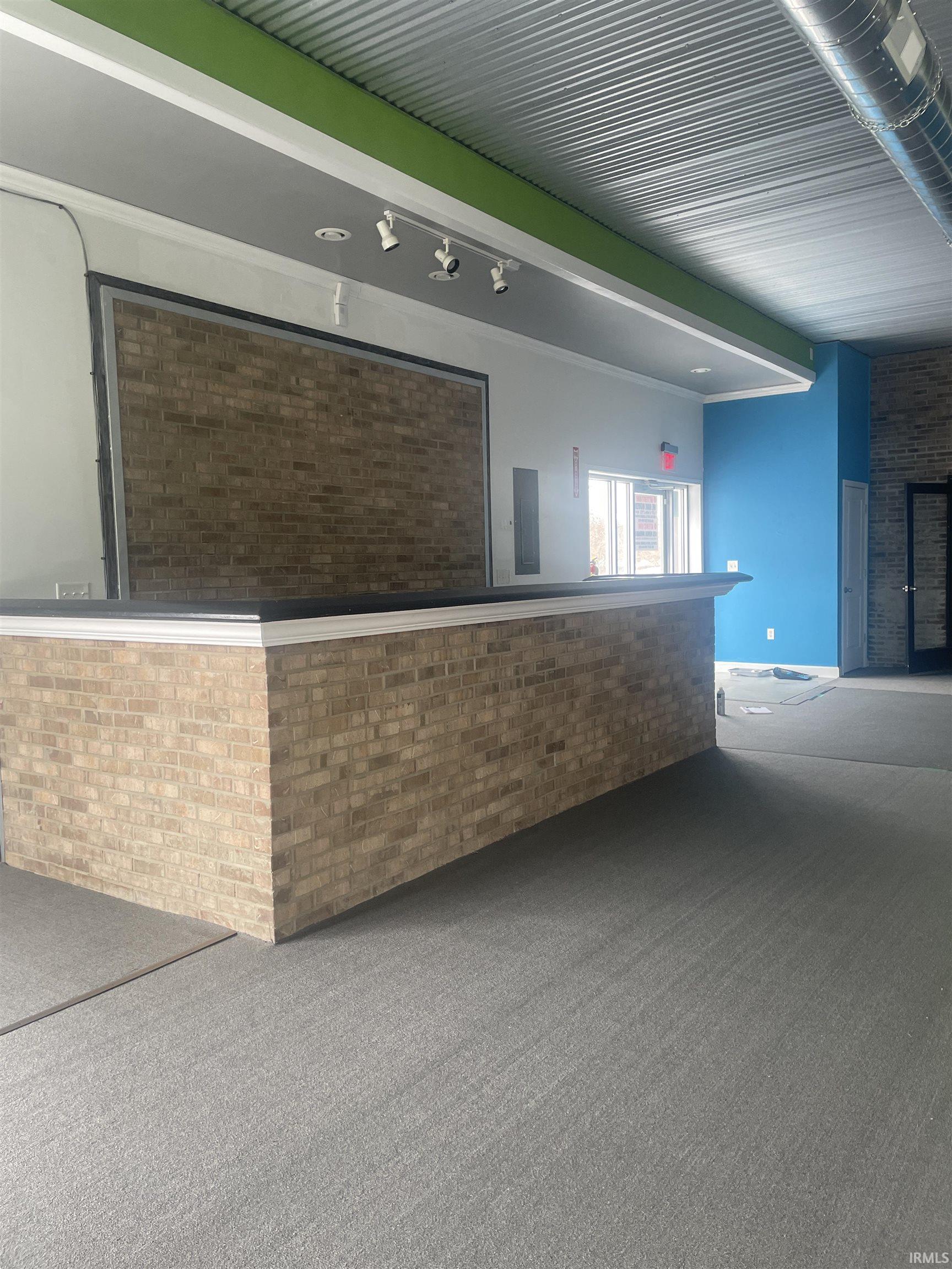 Reception area featuring brick wall and beamed ceiling