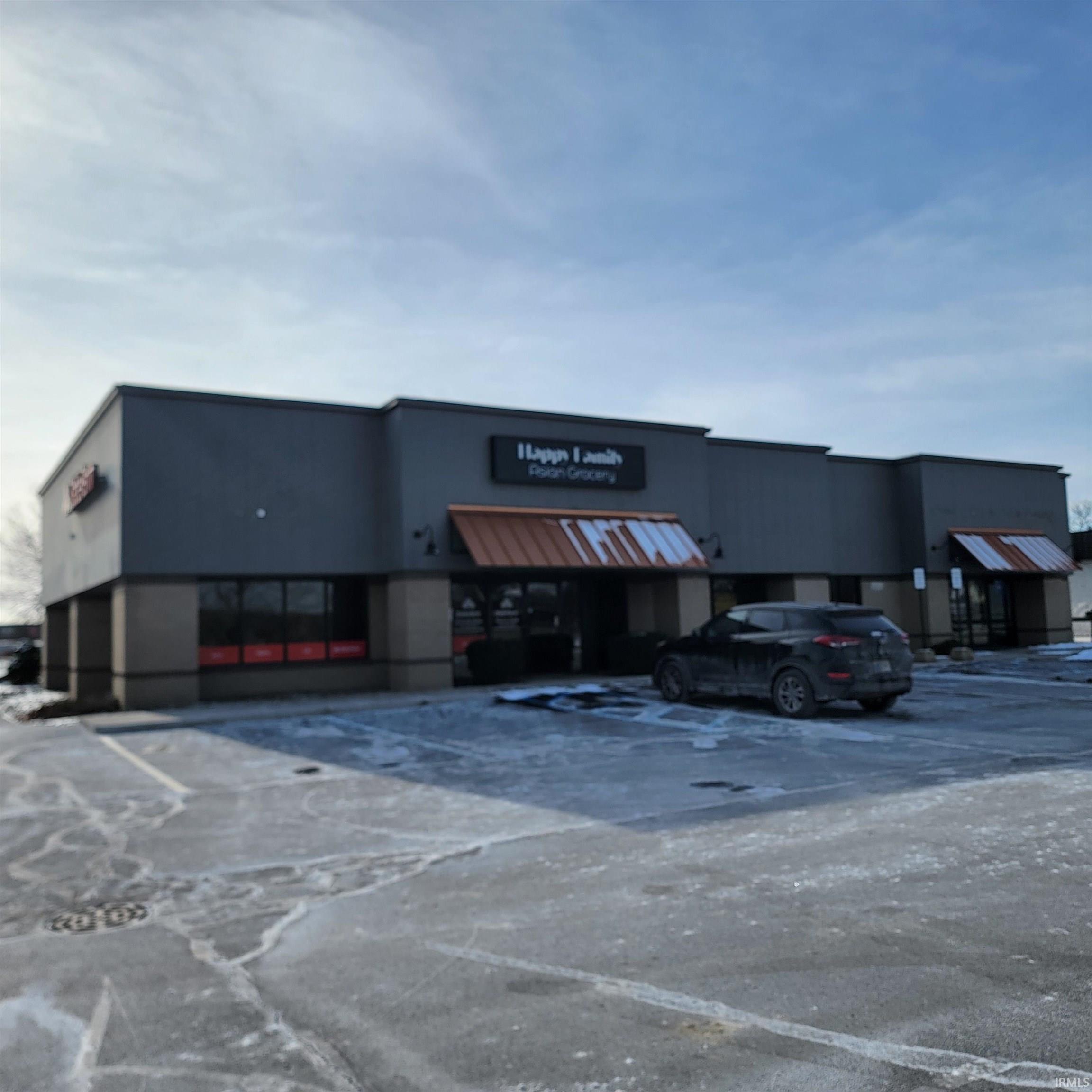 View of commercial property featuring uncovered parking