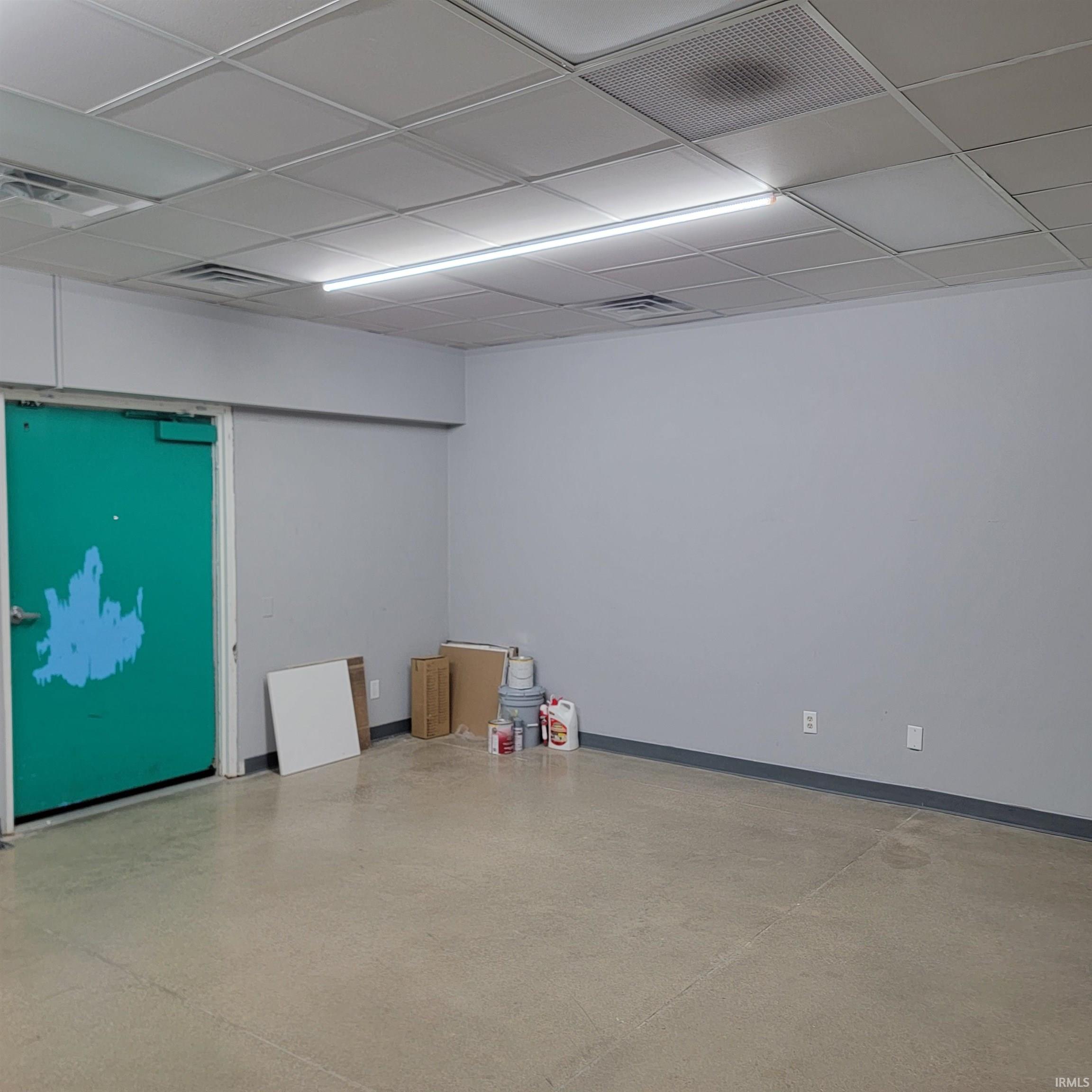 Empty room with a paneled ceiling and baseboards