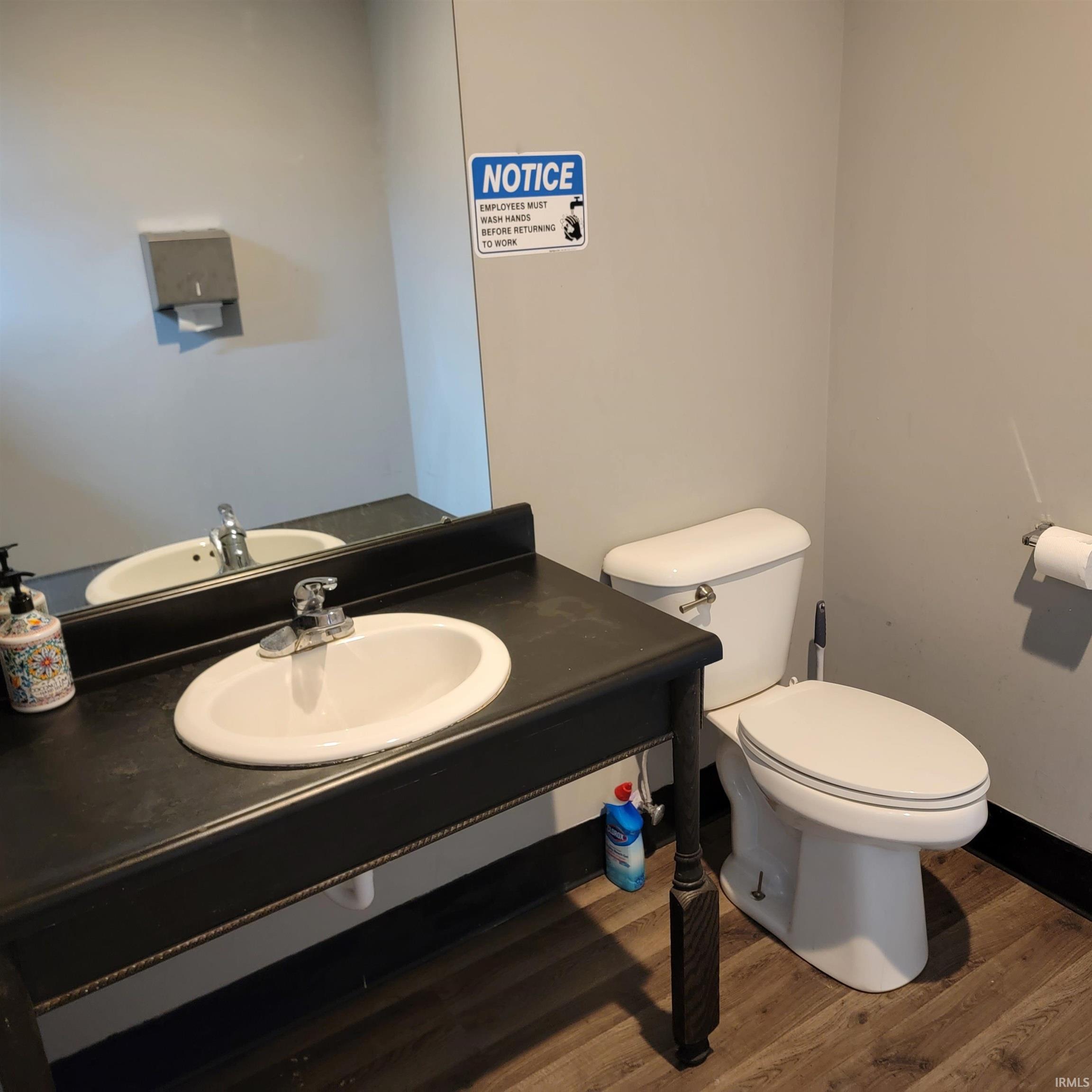 Half bath with wood finished floors and vanity