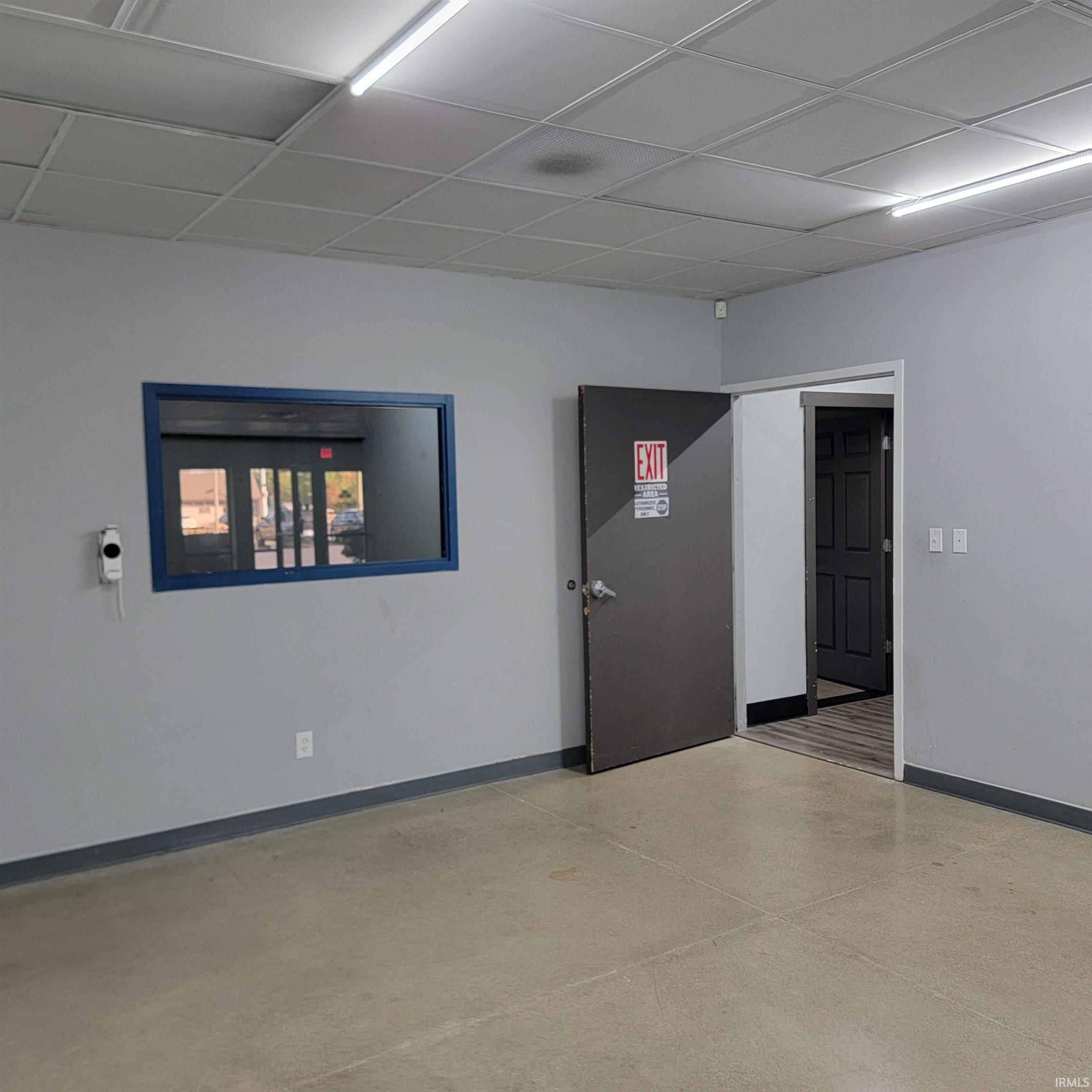 Empty room with baseboards and a drop ceiling