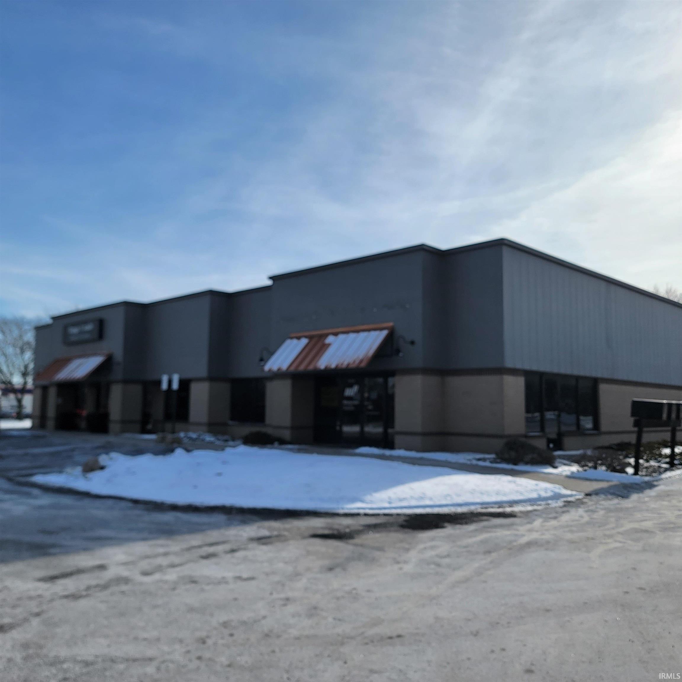 Snow covered building featuring view of commercial area