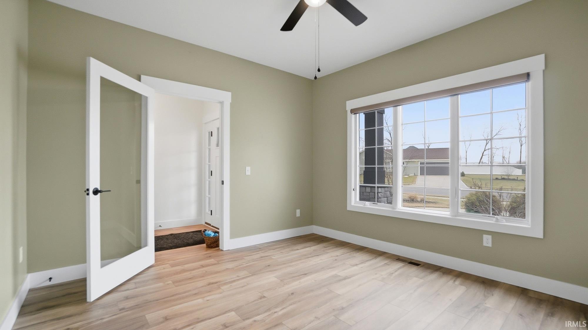 Unfurnished room with light wood-type flooring and ceiling fan