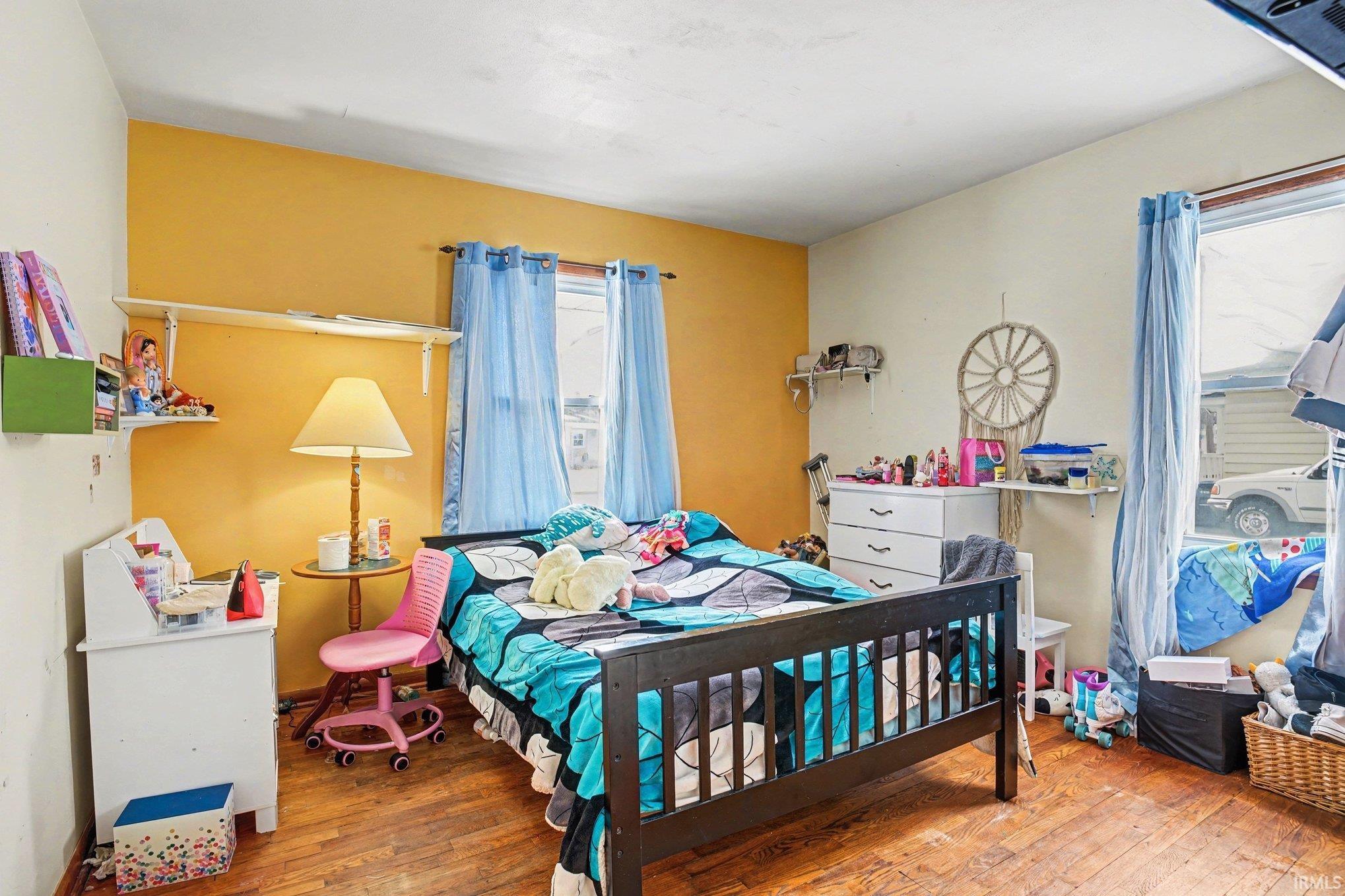 Bedroom with hardwood / wood-style flooring and multiple windows