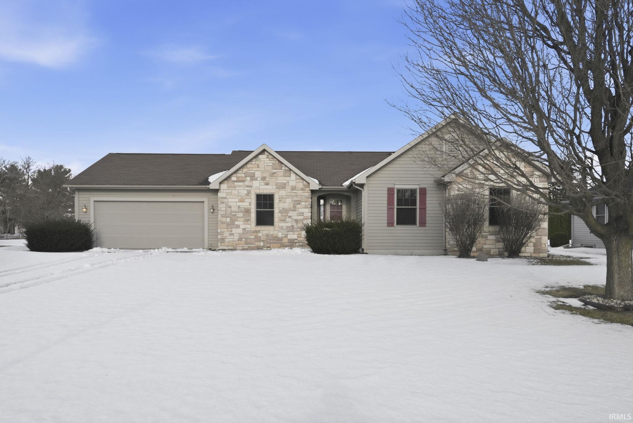 Single story home with stone siding and an attached garage