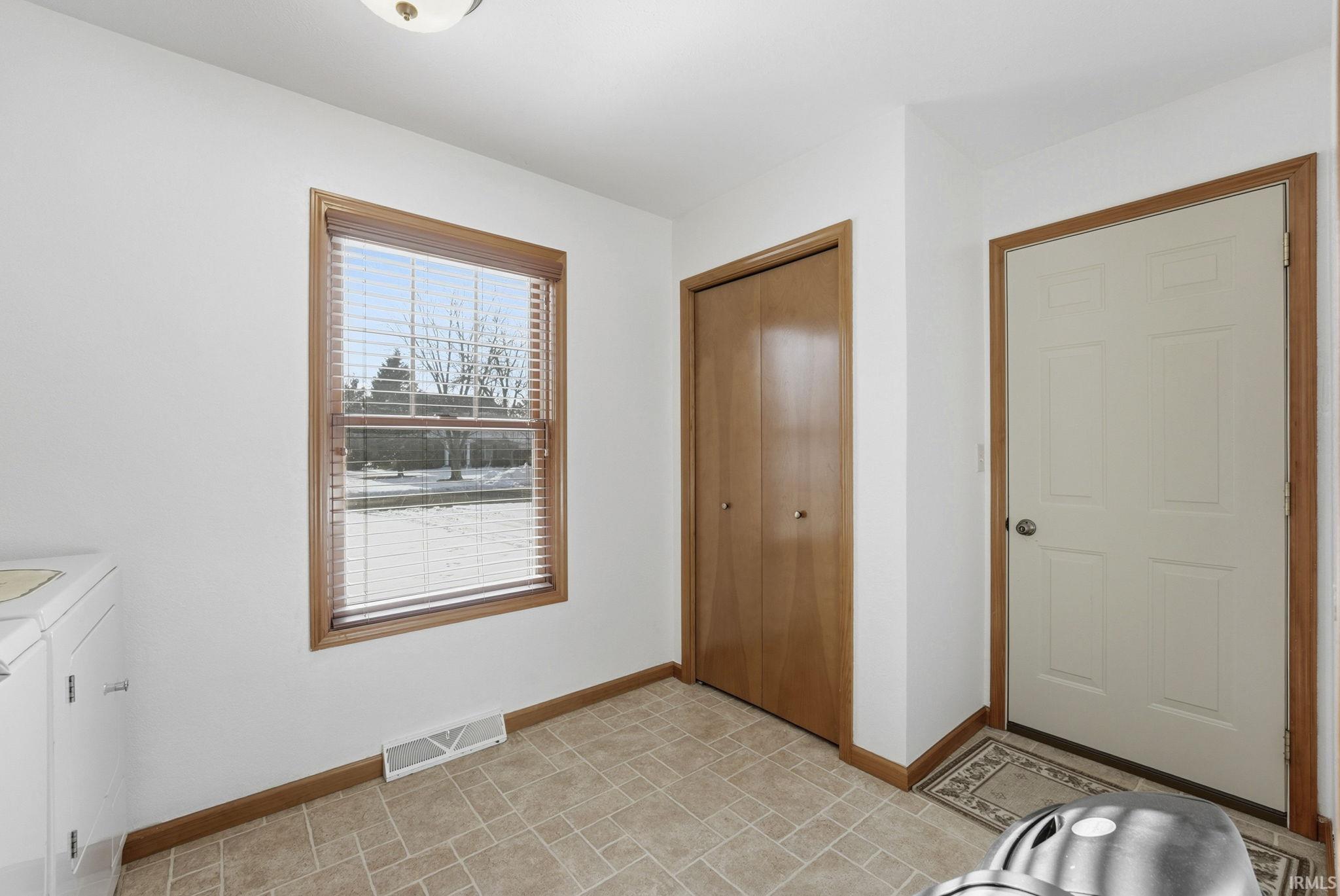 Unfurnished bedroom with a closet and independent washer and dryer