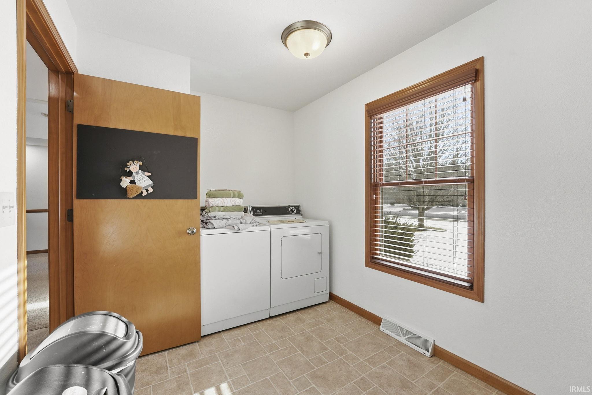 Laundry room with baseboards and washer and clothes dryer