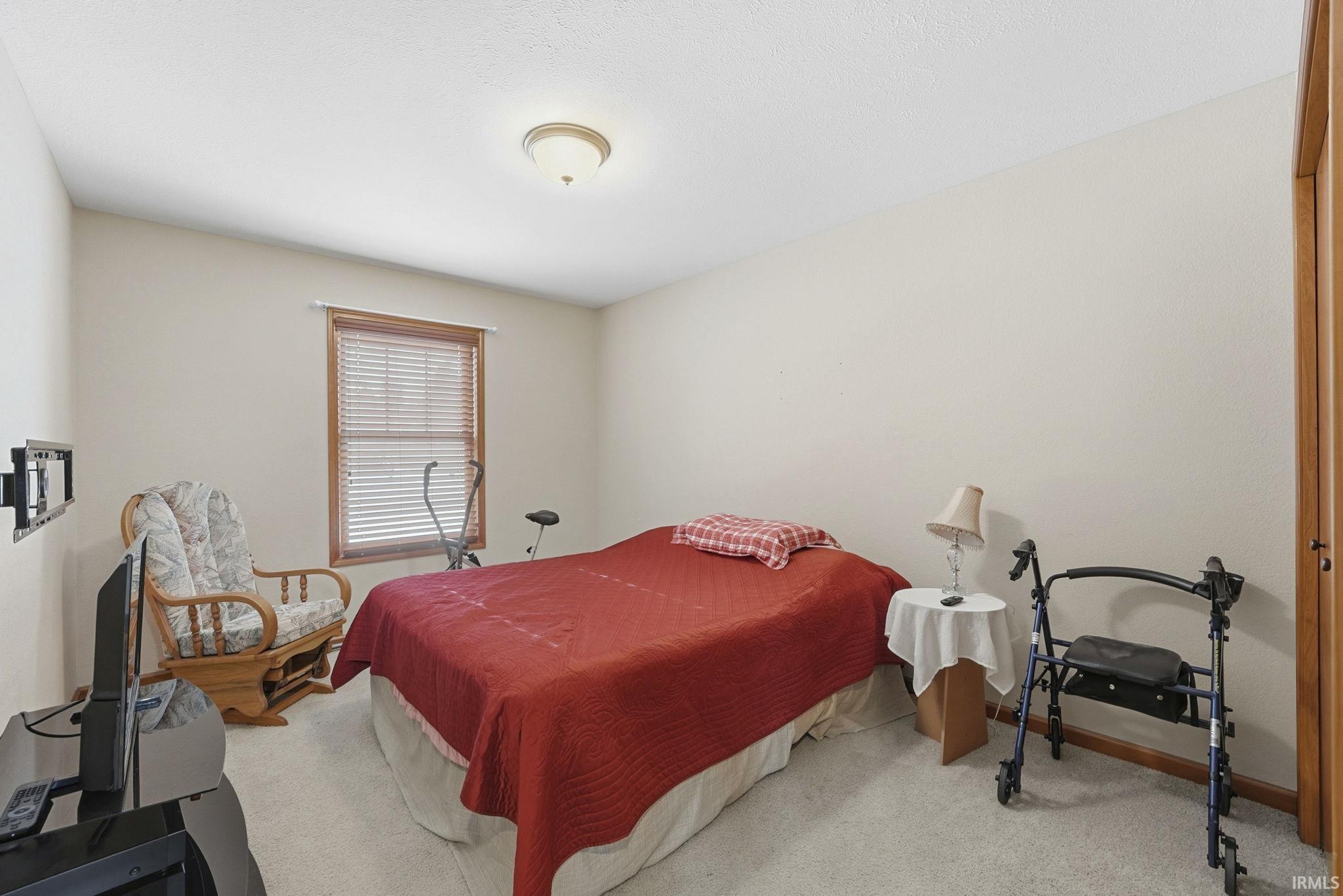 Bedroom with light carpet and baseboards