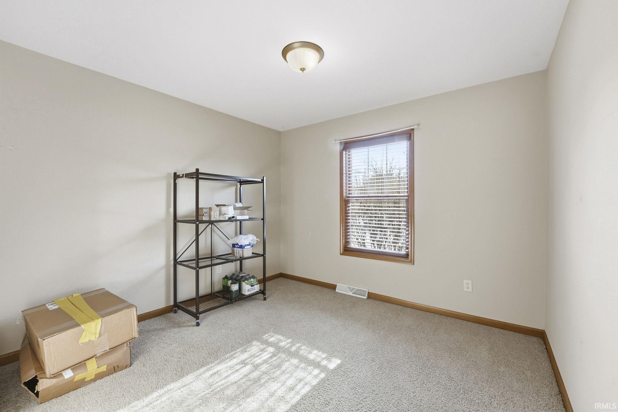 Empty room featuring carpet and baseboards