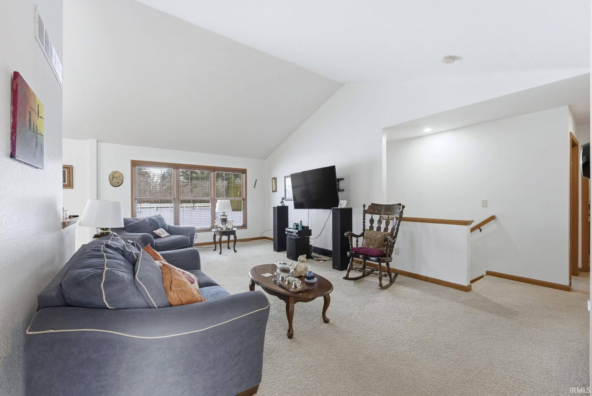 Living area featuring carpet and lofted ceiling