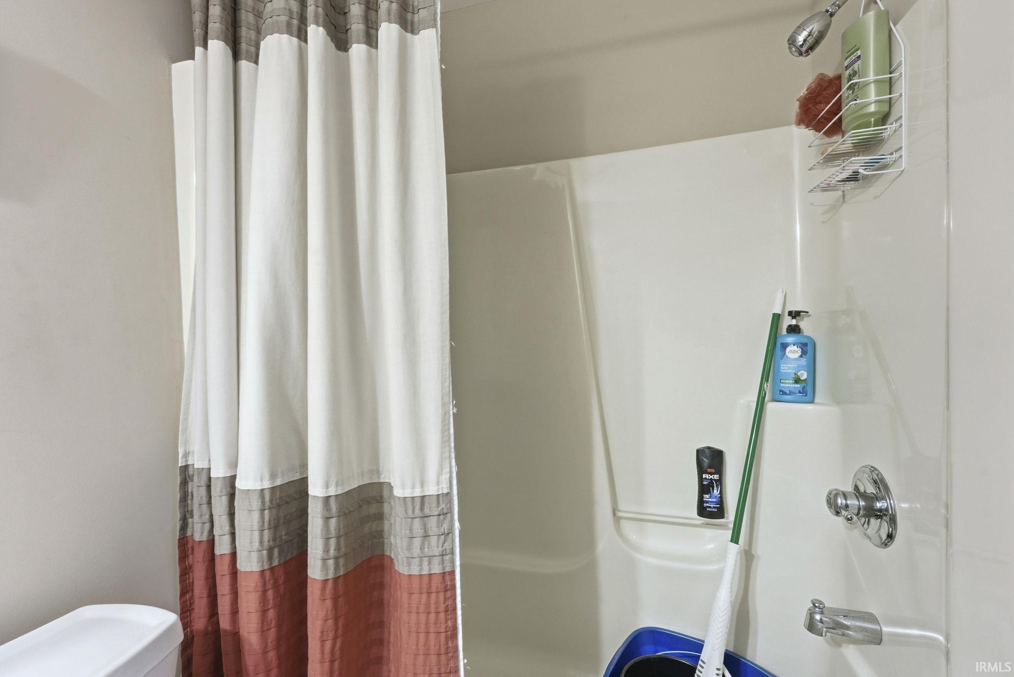 Full bathroom with toilet and shower / bathtub combination with curtain