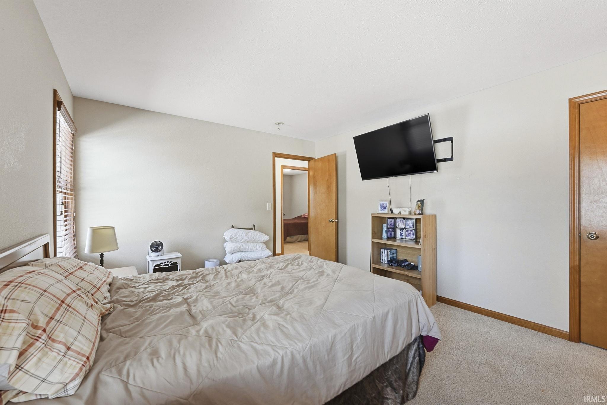 Bedroom featuring baseboards and light carpet
