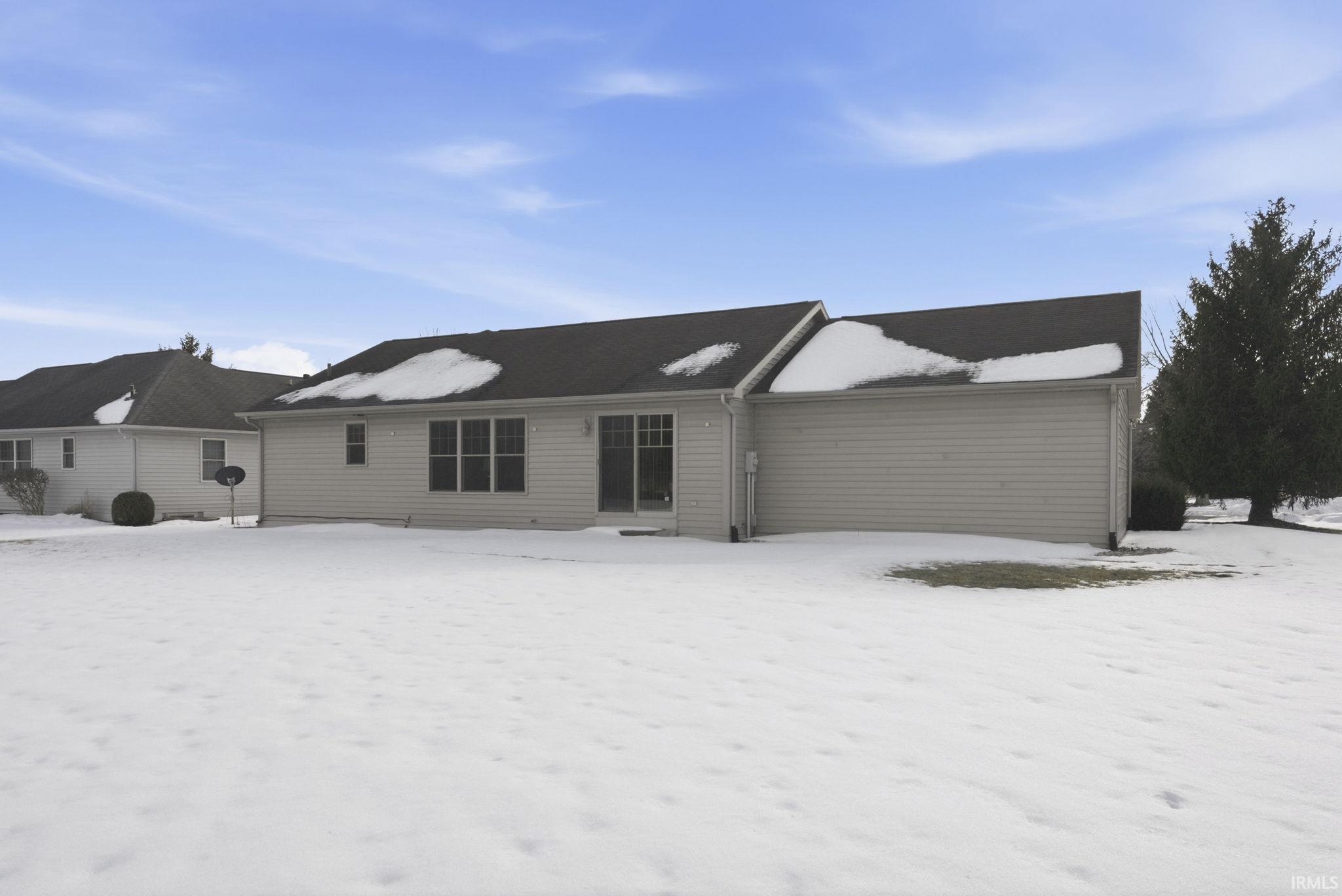 View of snow covered back of property