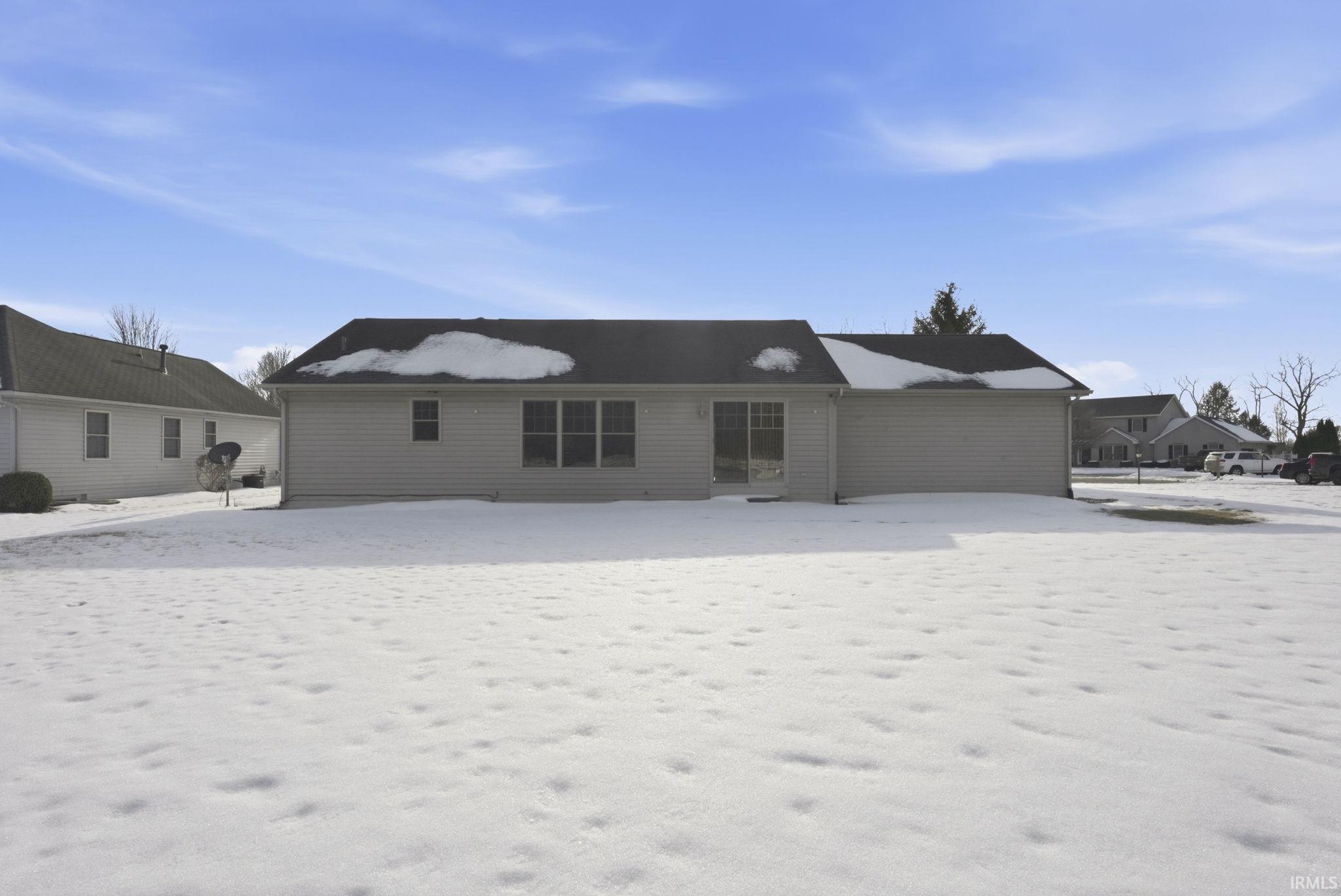 View of snow covered back of property