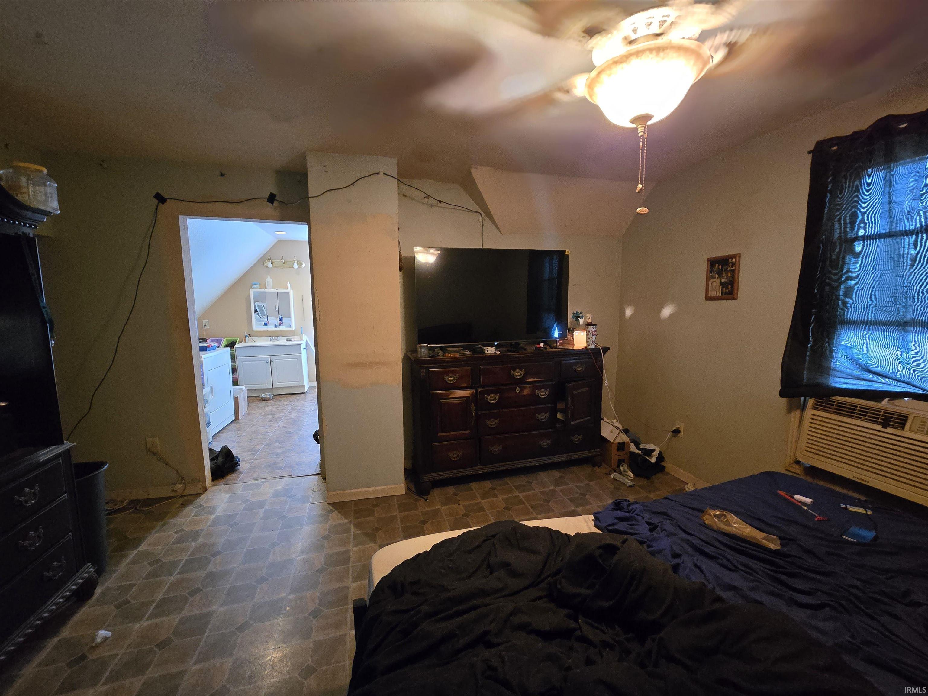 Bedroom featuring lofted ceiling, a ceiling fan, and cooling unit