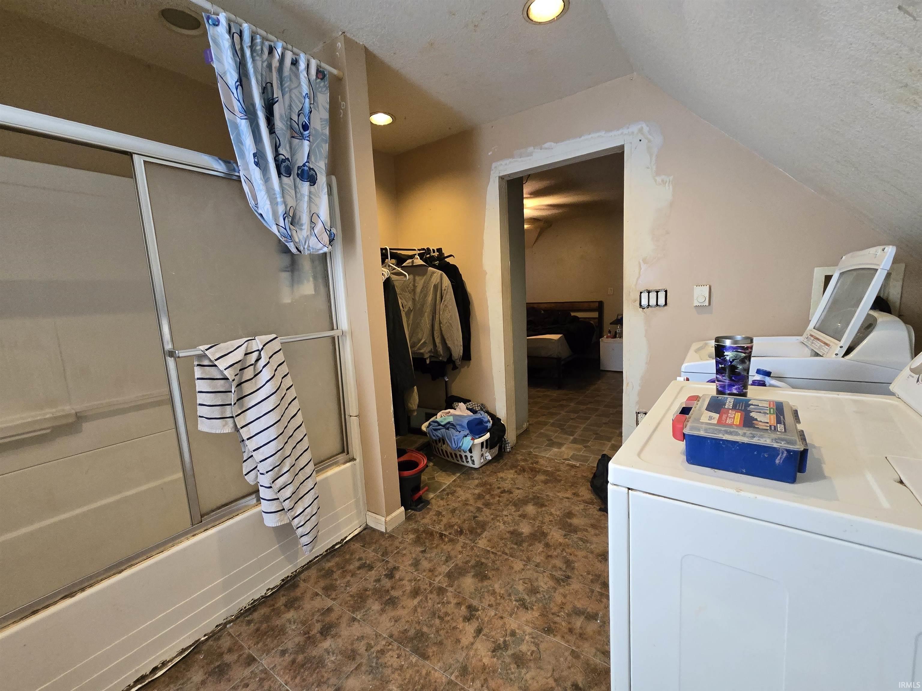 Ensuite bathroom with vanity, bath / shower combo with glass door, washer and dryer, and recessed lighting