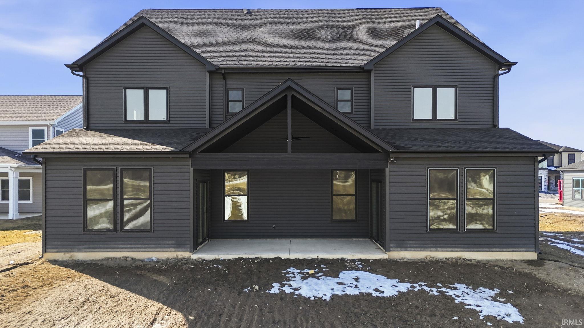 Back of house featuring a shingled roof and a patio