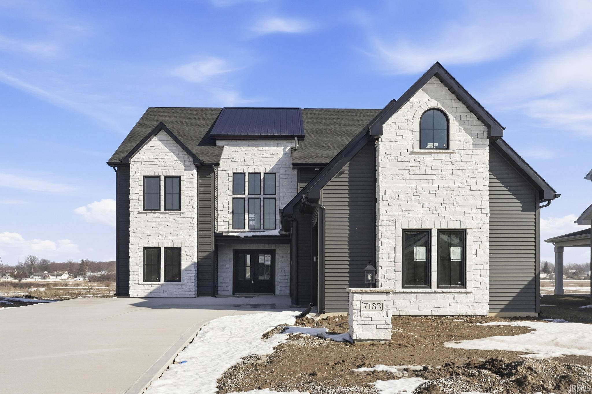 French country inspired facade with stone siding