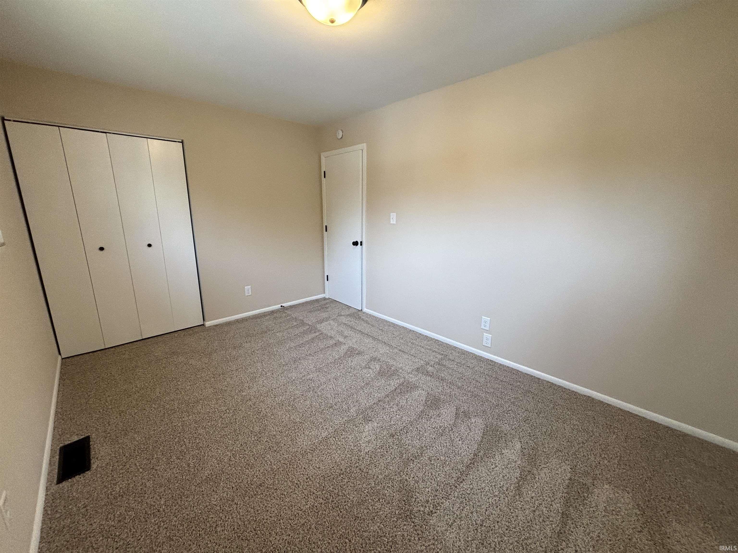 Unfurnished bedroom featuring carpet floors and a closet