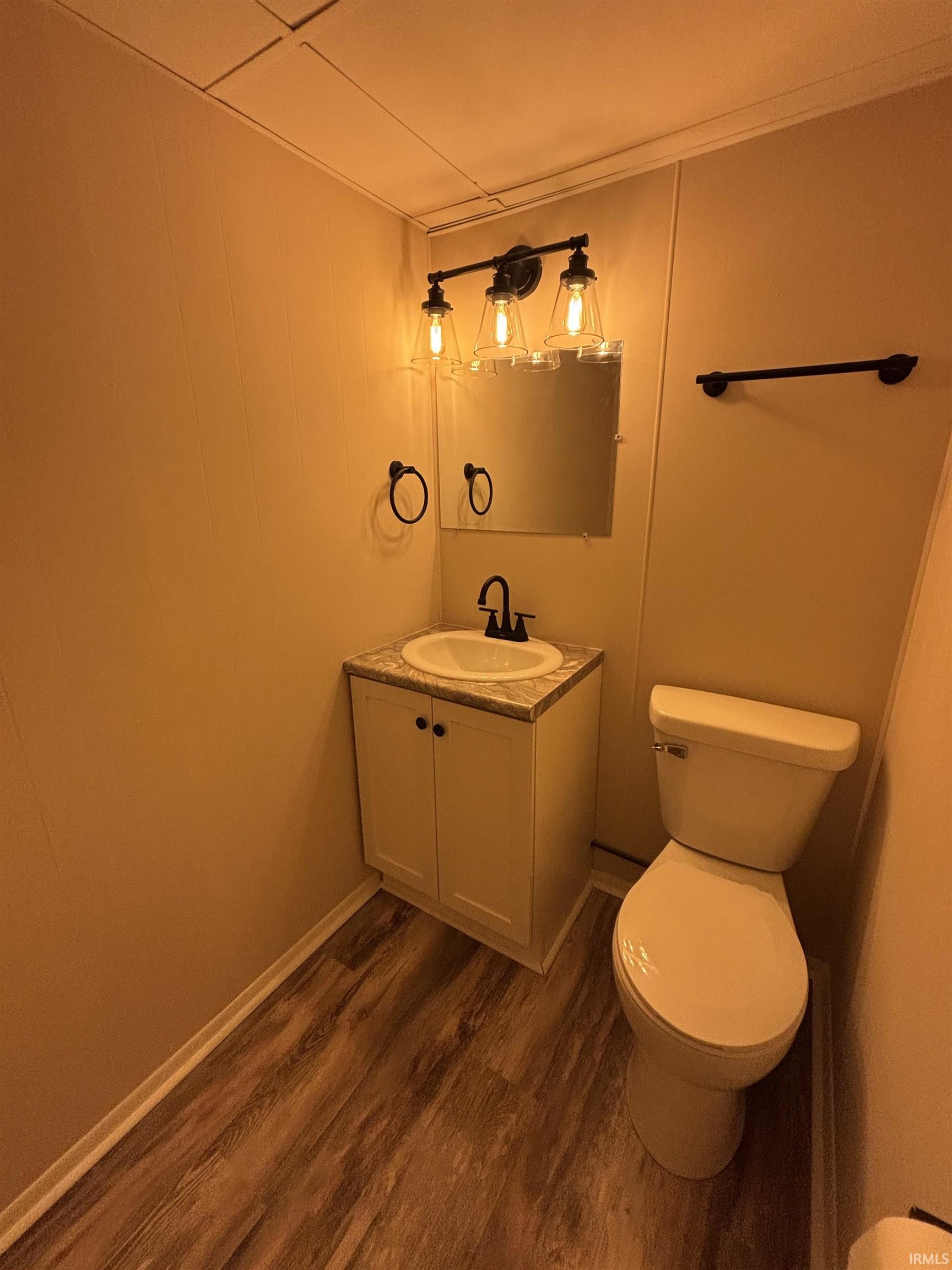 Half bath with vanity and dark wood-style flooring