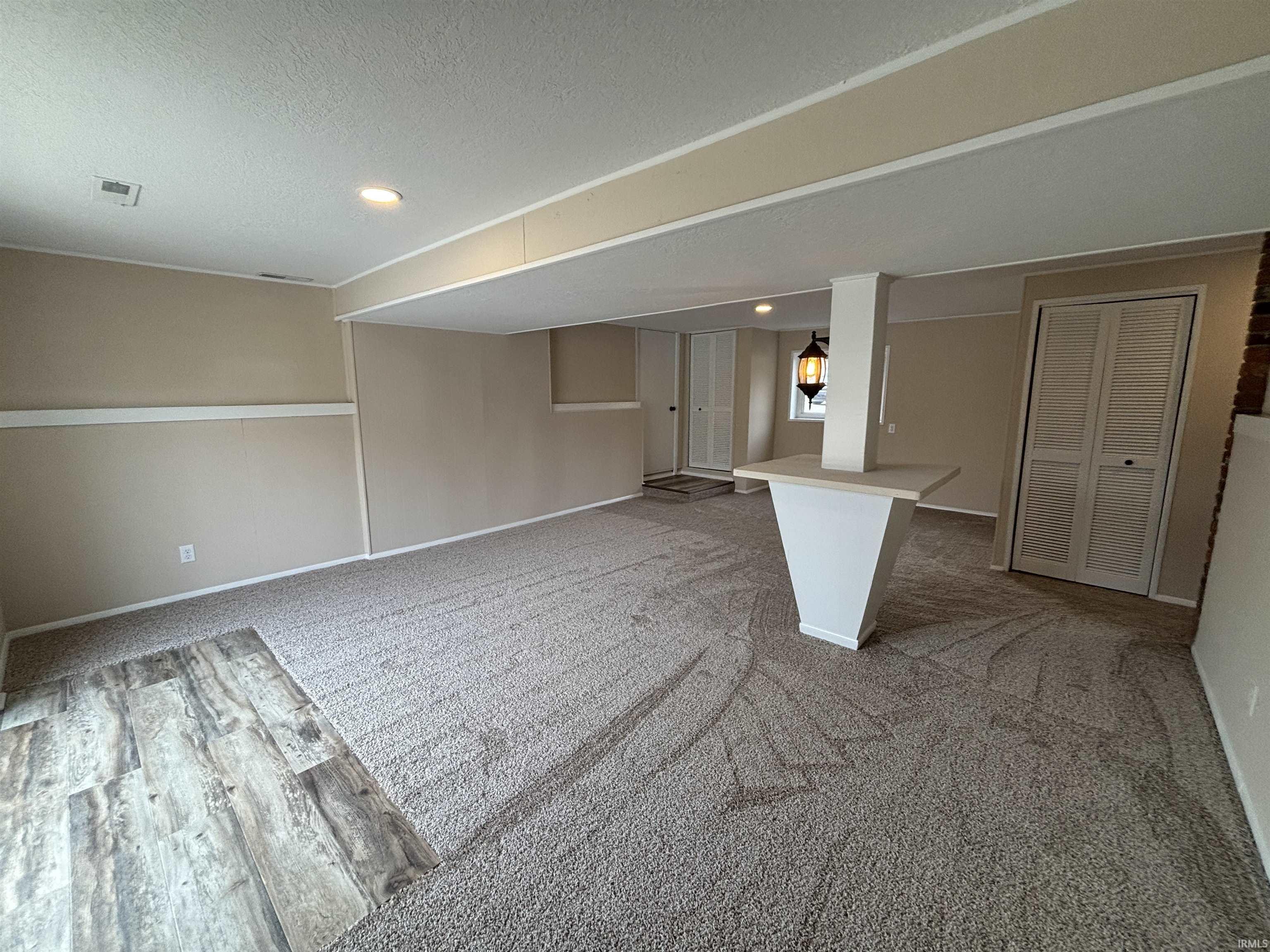 Finished below grade area featuring recessed lighting, light colored carpet, and a textured ceiling