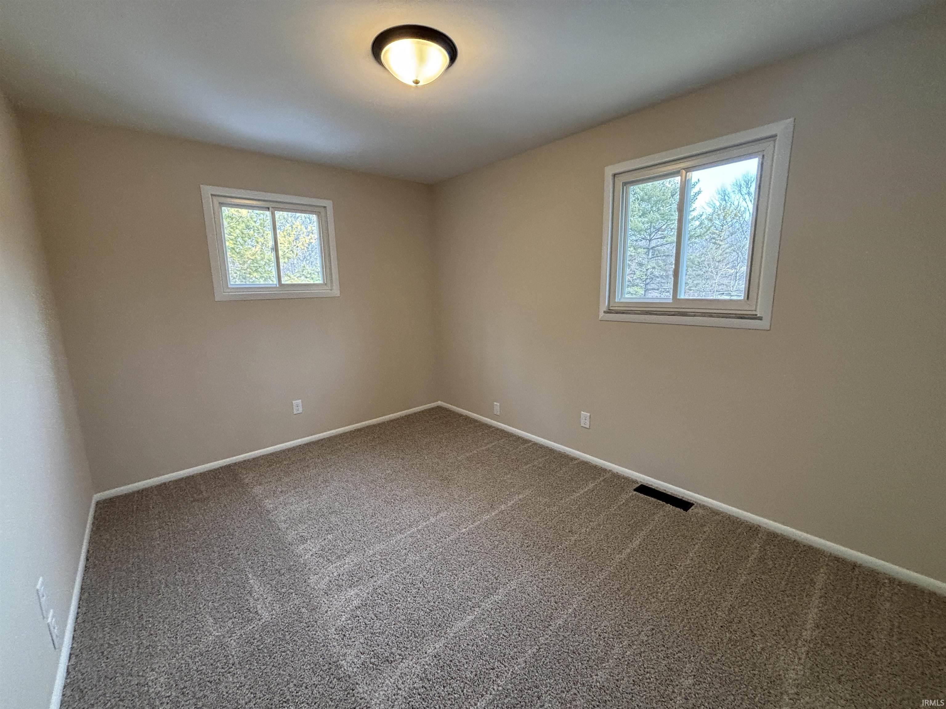 Carpeted empty room featuring baseboards