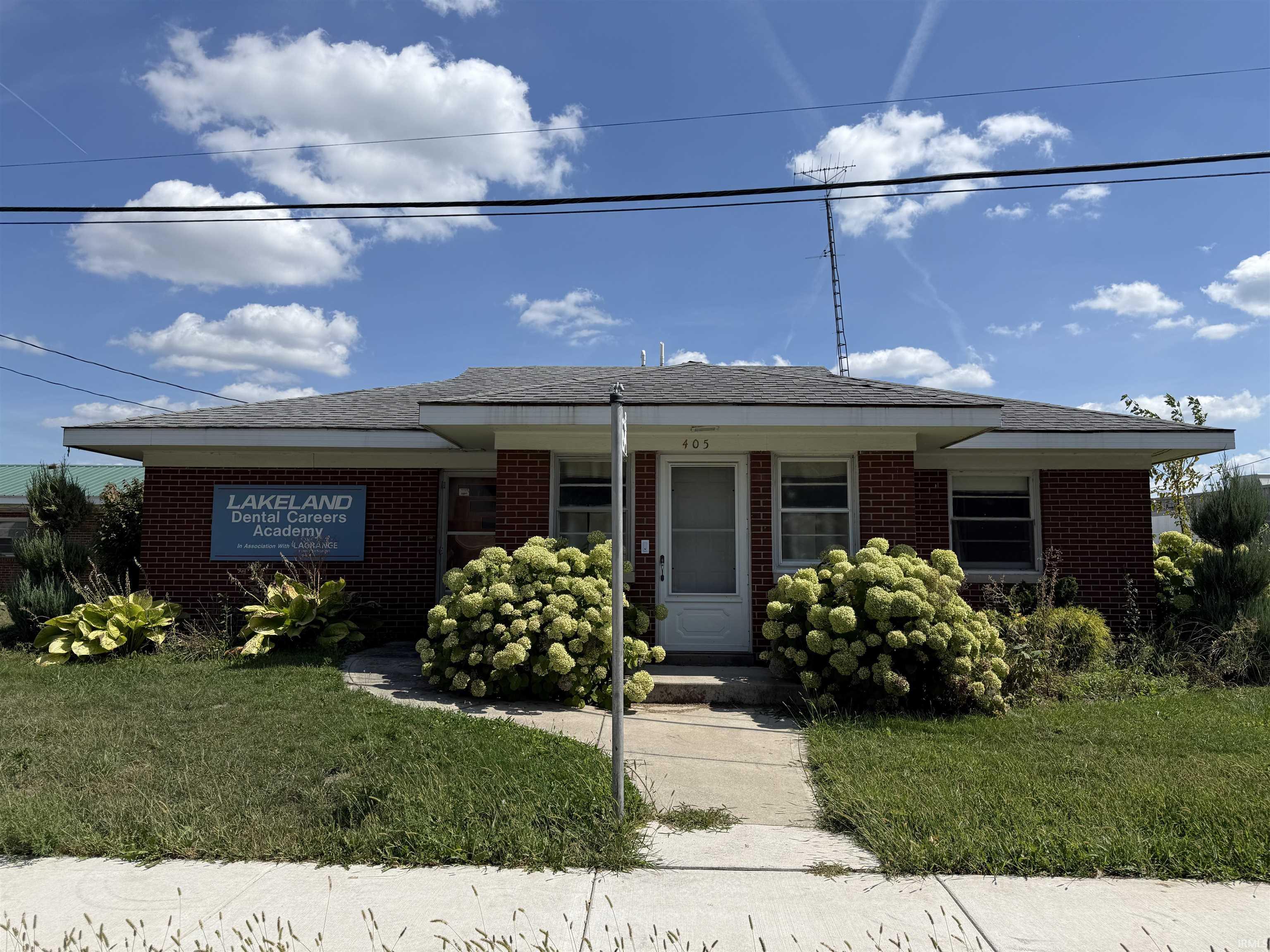 Ranch-style home with a front lawn, brick siding, and roof with shingles