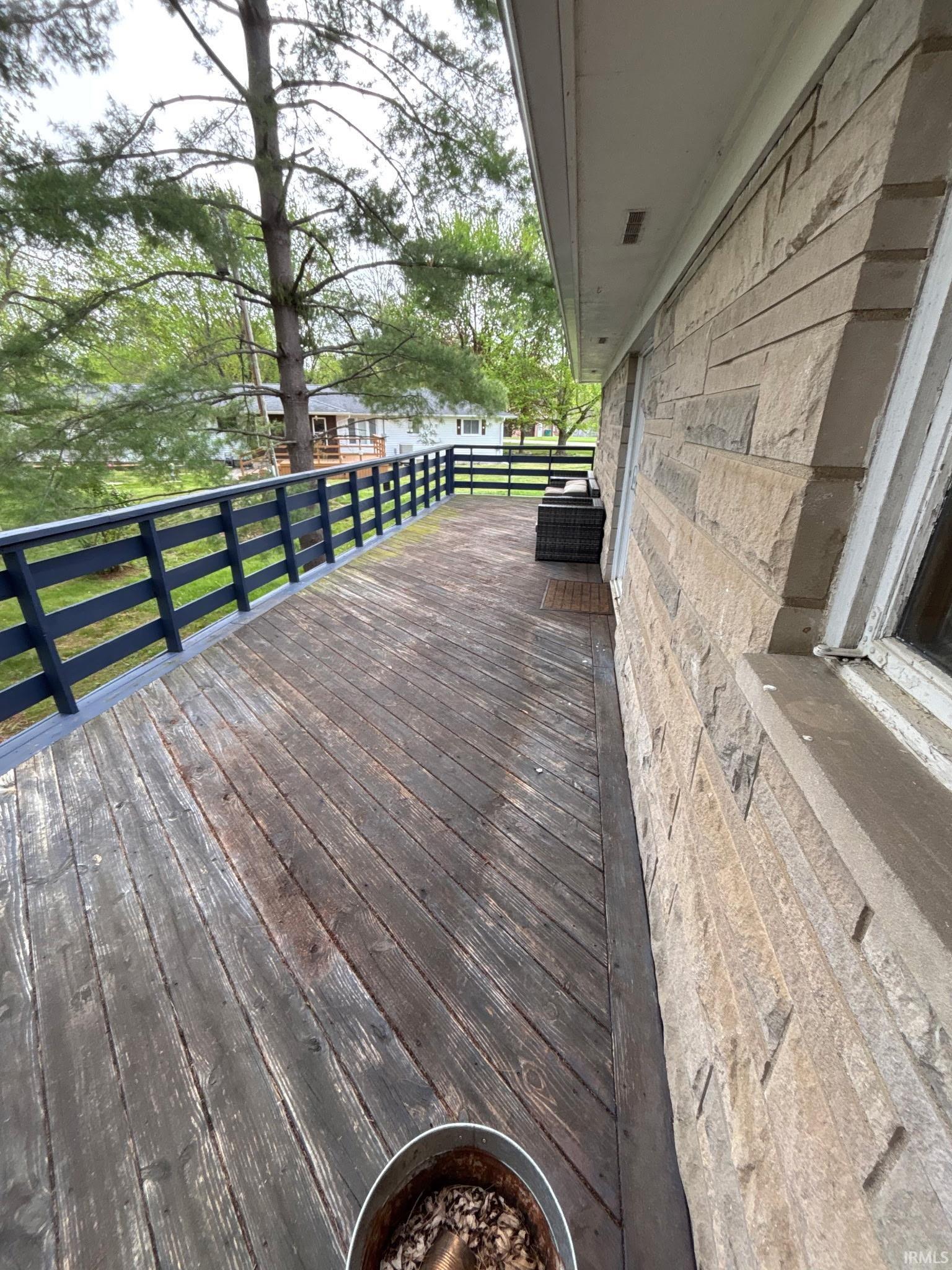 Expansive outdoor deck featuring wood flooring and dark-toned railings