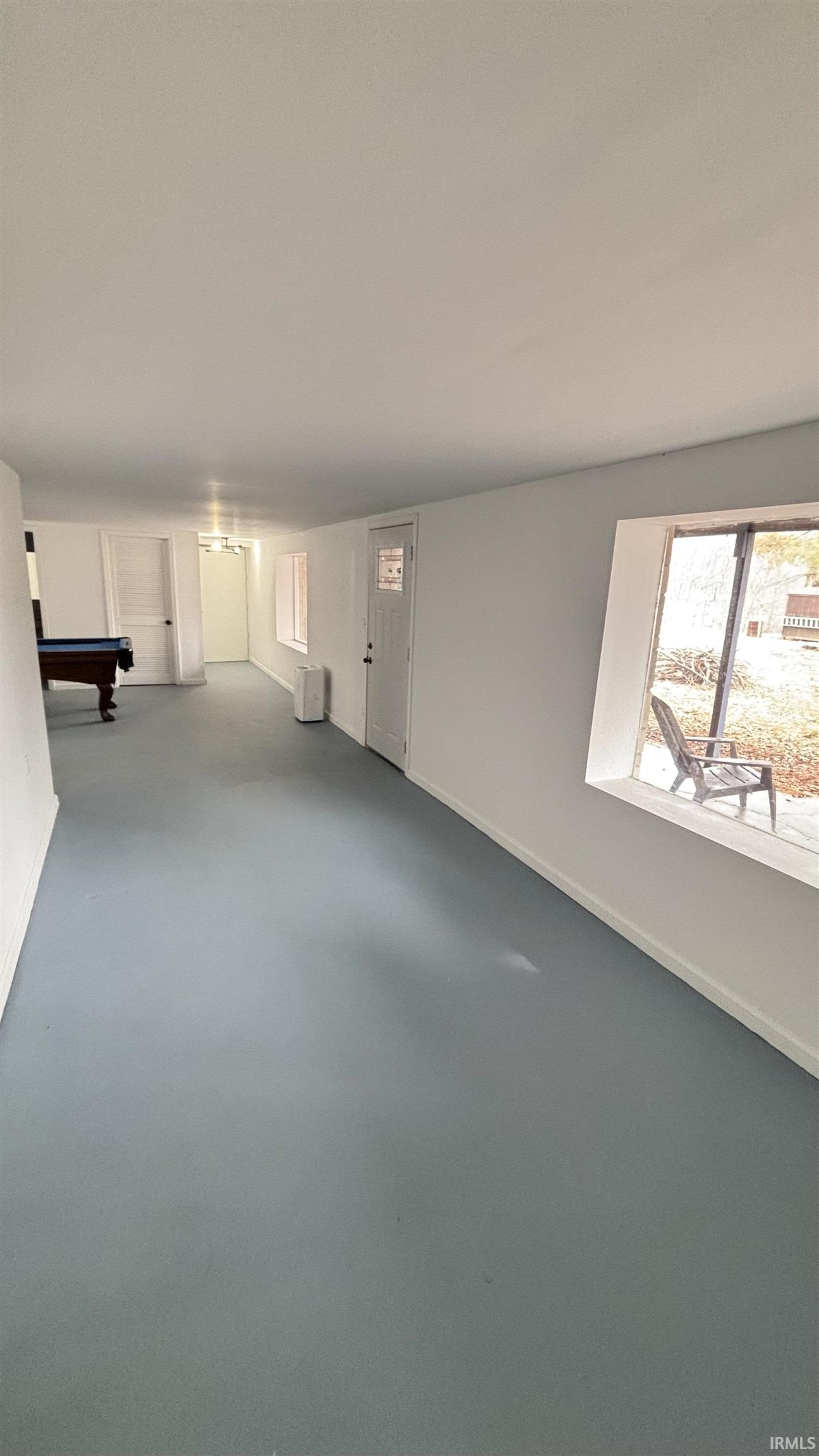 Unfurnished living room featuring baseboards and billiards