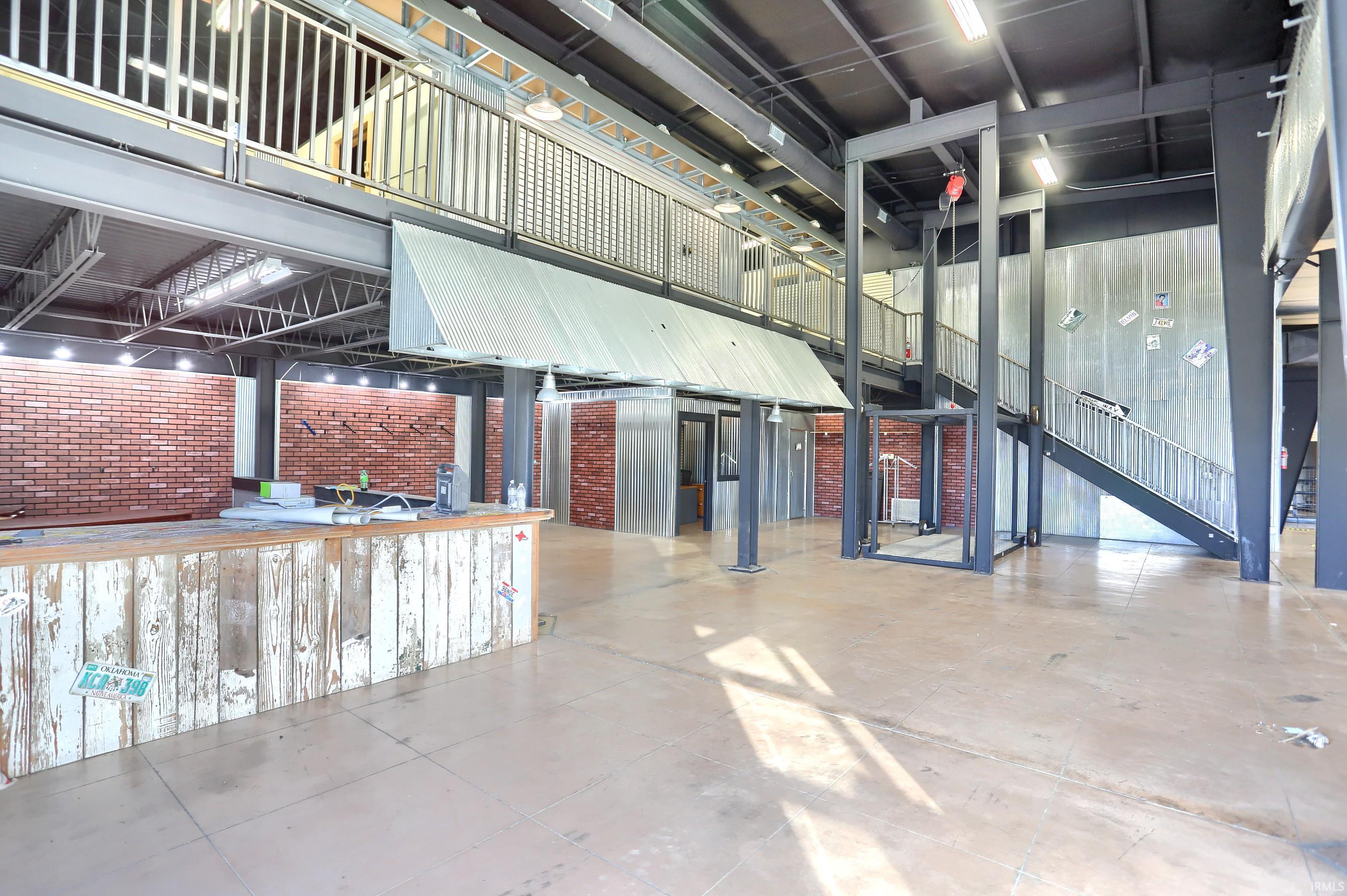View of community featuring a high ceiling and brick wall