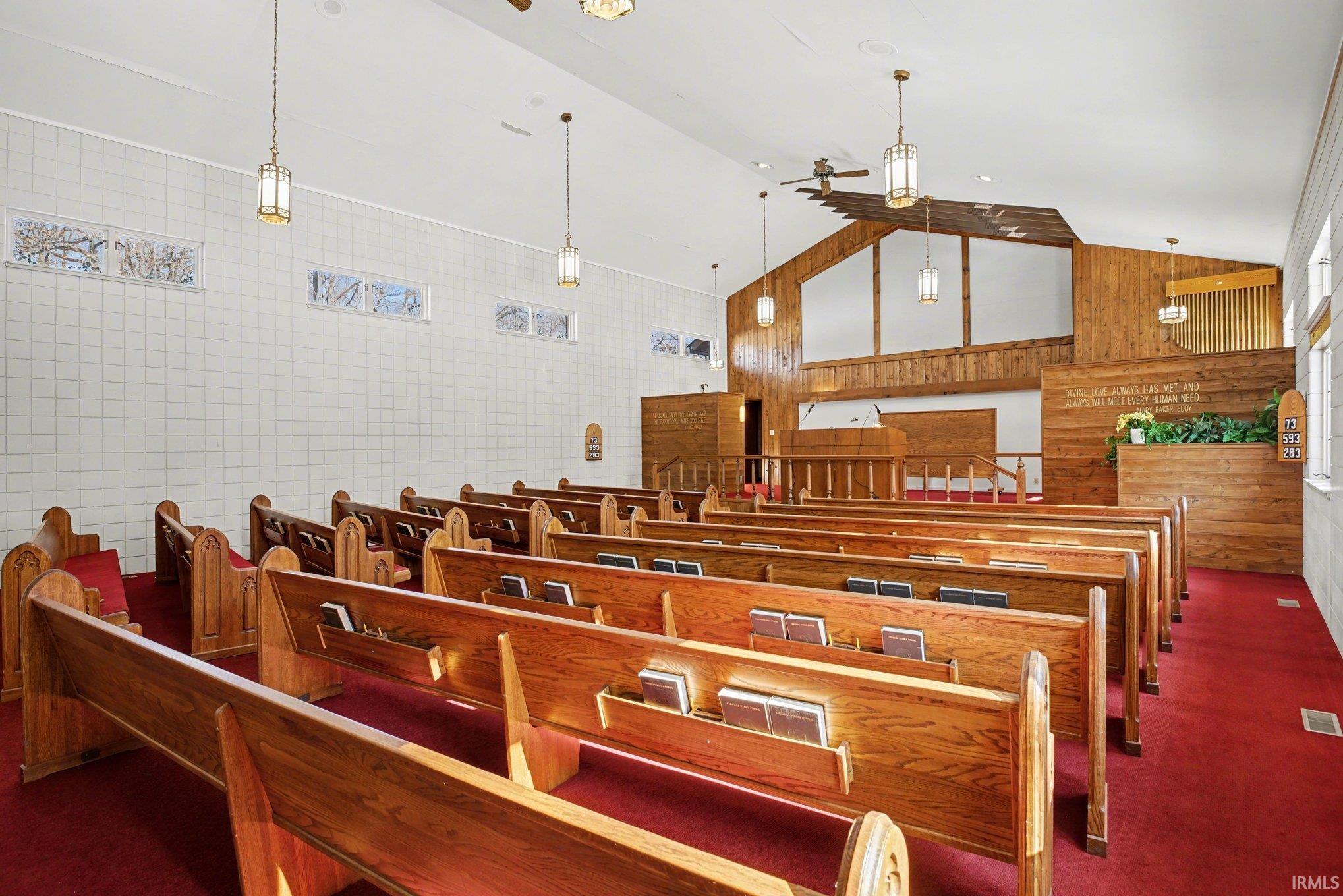 Misc room with a high ceiling and wood walls