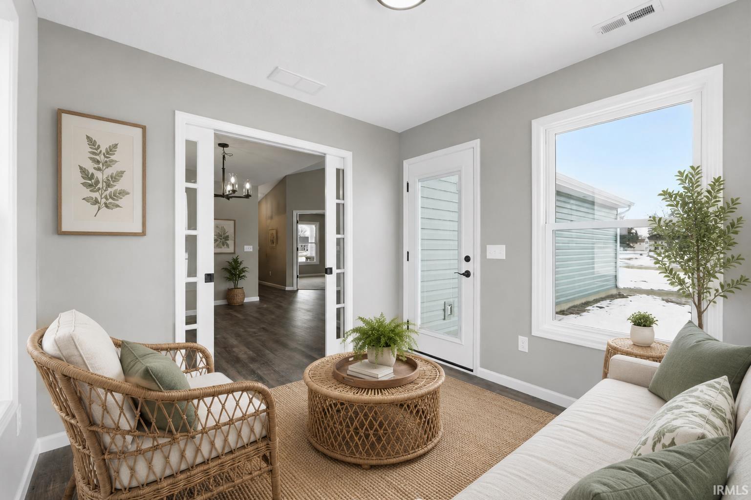 Sunroom featuring a full-light exterior door, a large window, recessed lighting, and wood-finish flooring