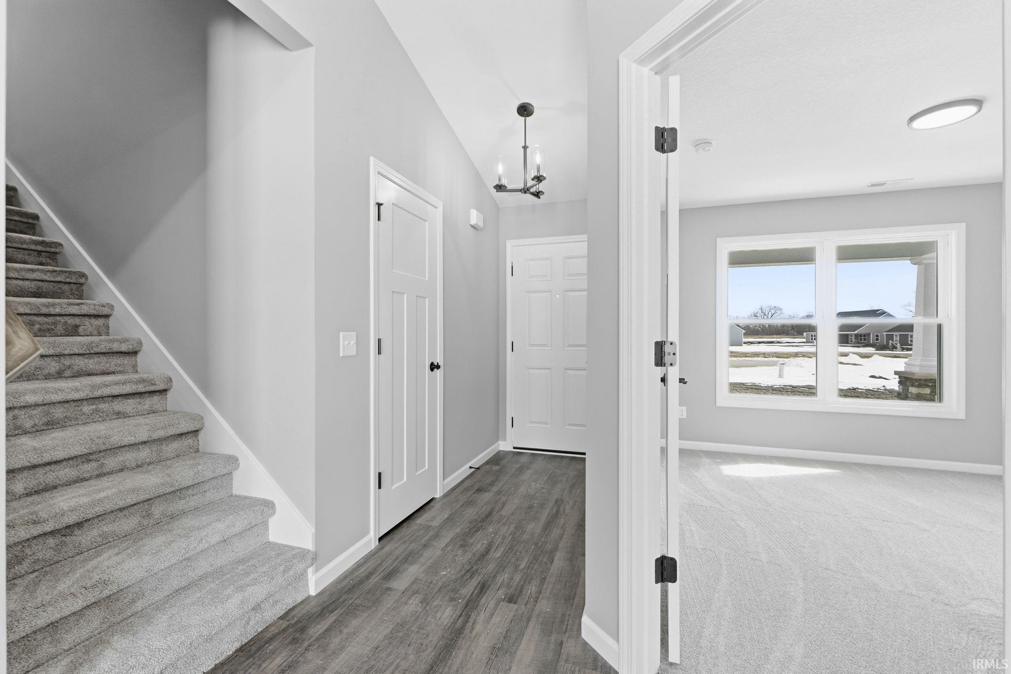 Entrance foyer featuring suspended lighting and dark wood finished floors