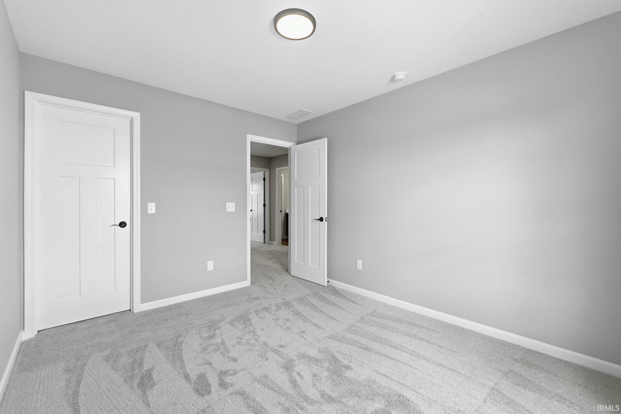 Unfurnished bedroom featuring carpet floors and baseboards