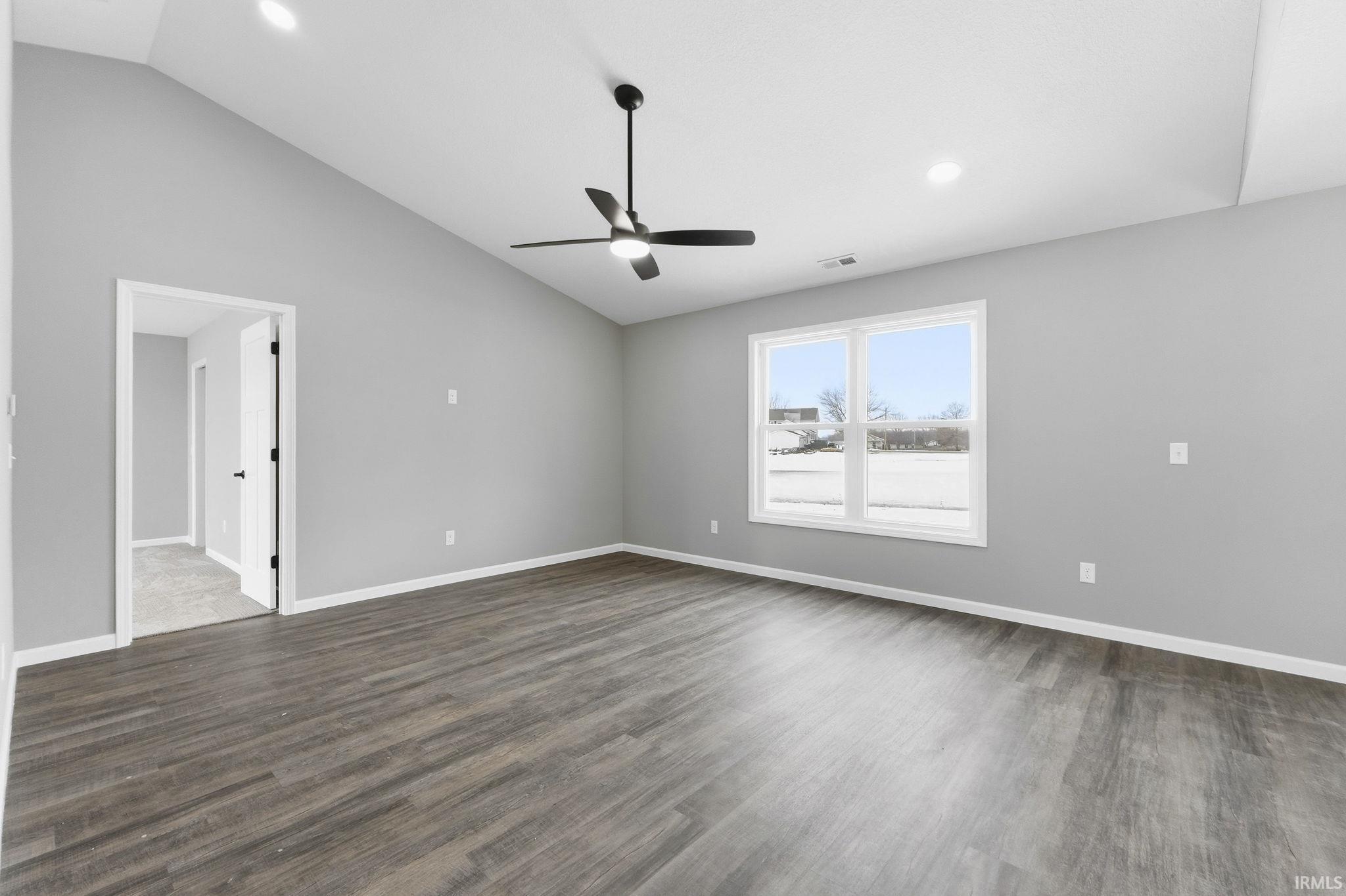 Spare room featuring lofted ceiling, ceiling fan, recessed lighting, and dark wood finished floors