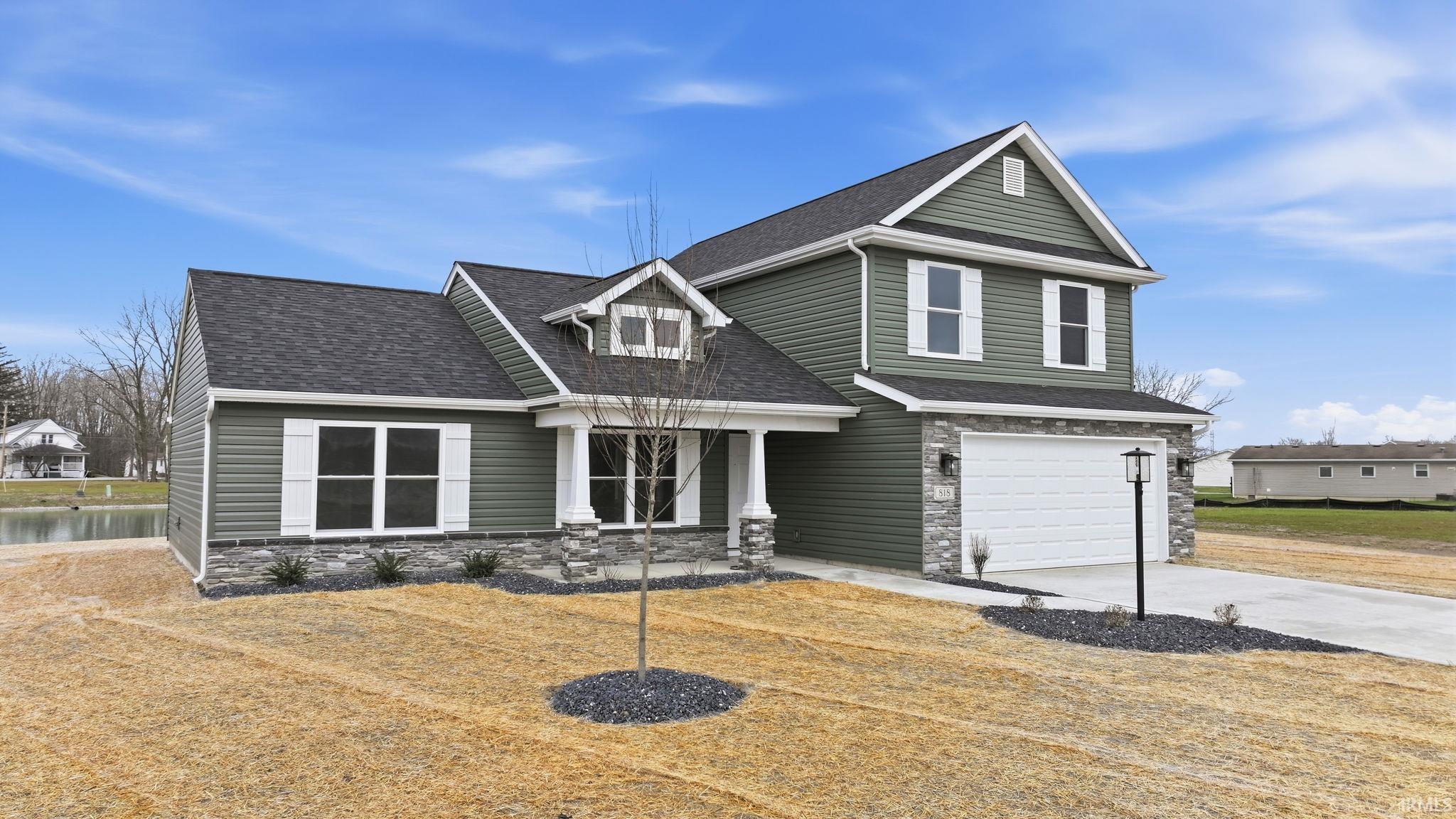 View of front facade featuring stone siding, roof with shingles, an attached garage, driveway, and a porch