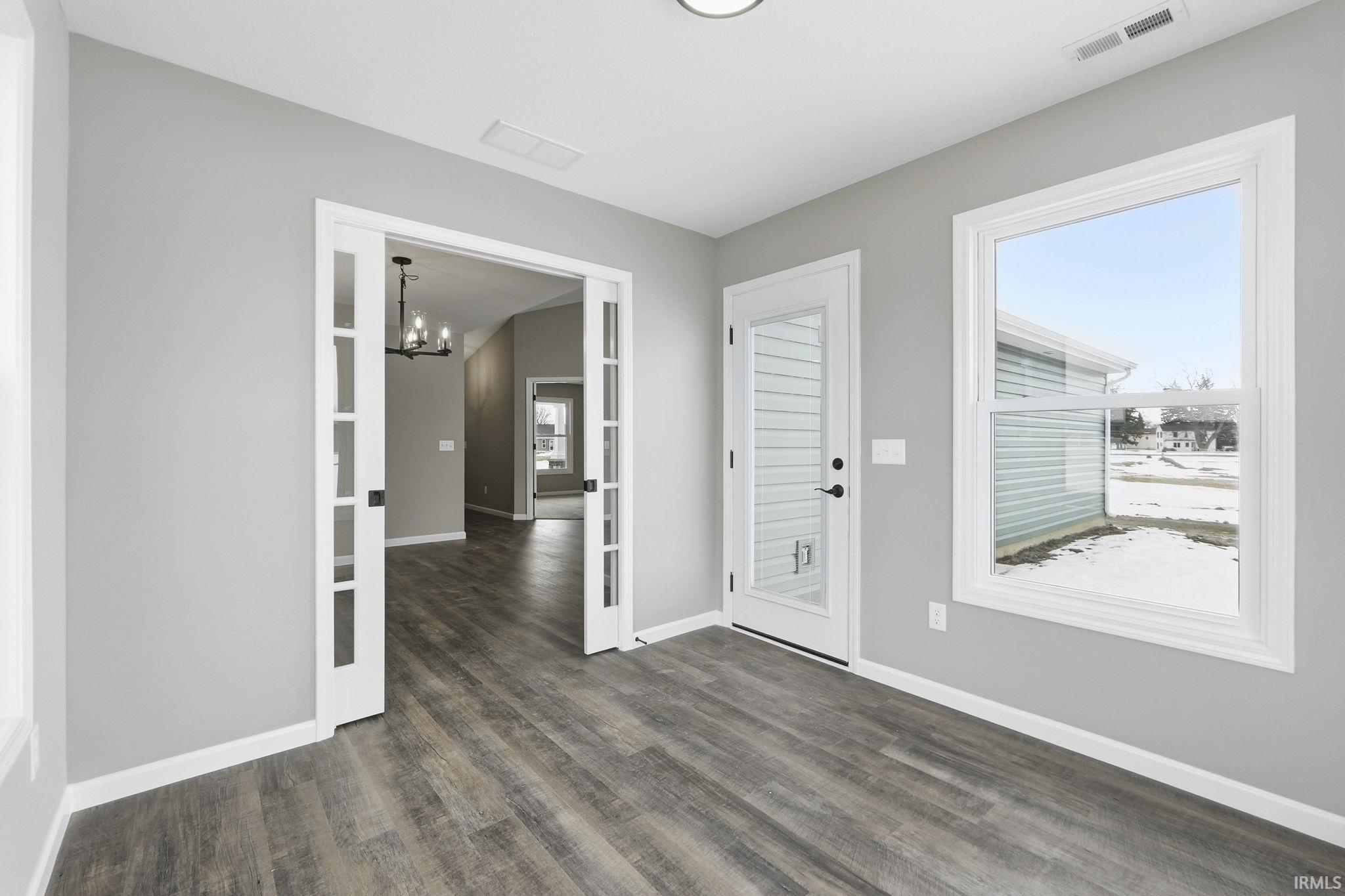 Entryway featuring plenty of natural light, dark wood-type flooring, and suspended lighting