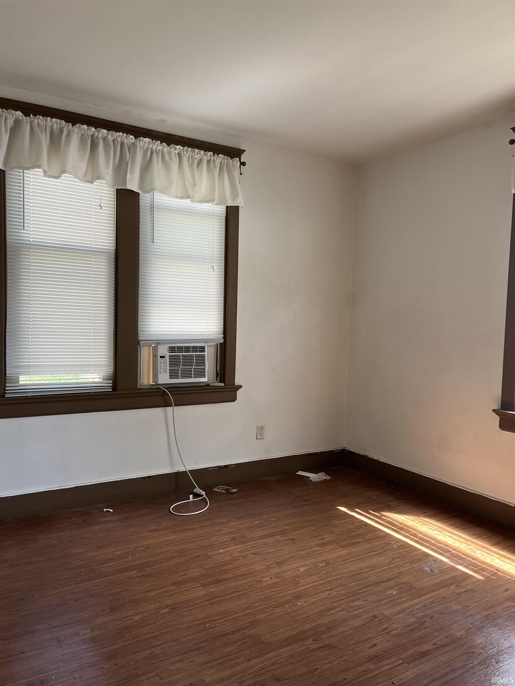 Unfurnished room featuring dark wood-style floors and cooling unit