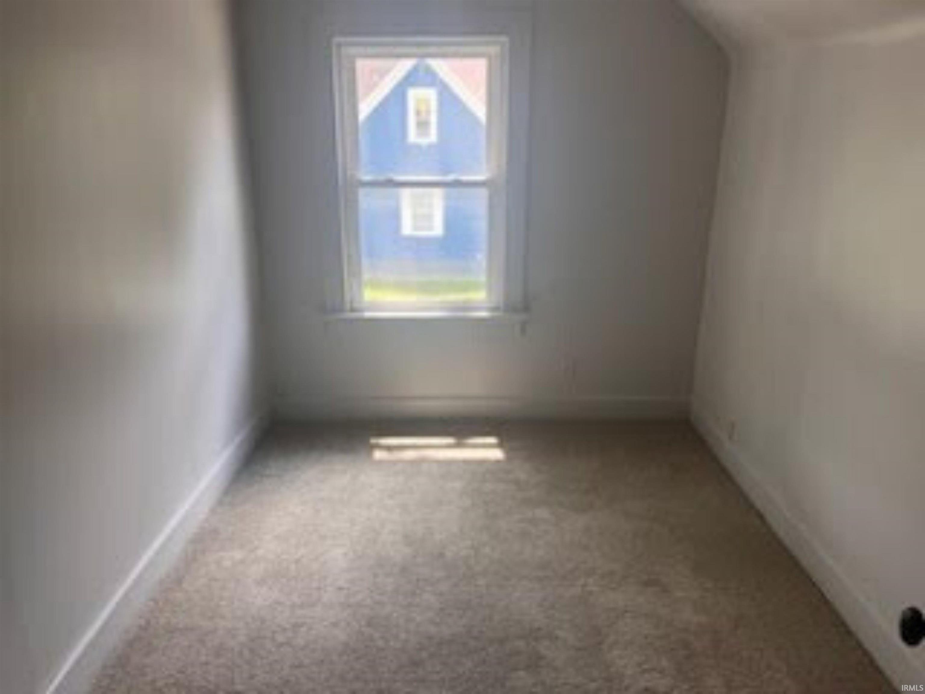 Additional living space featuring light colored carpet and vaulted ceiling