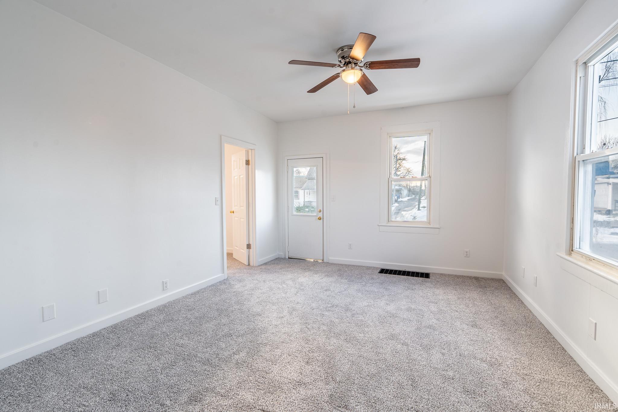 Spare room with light colored carpet and a ceiling fan