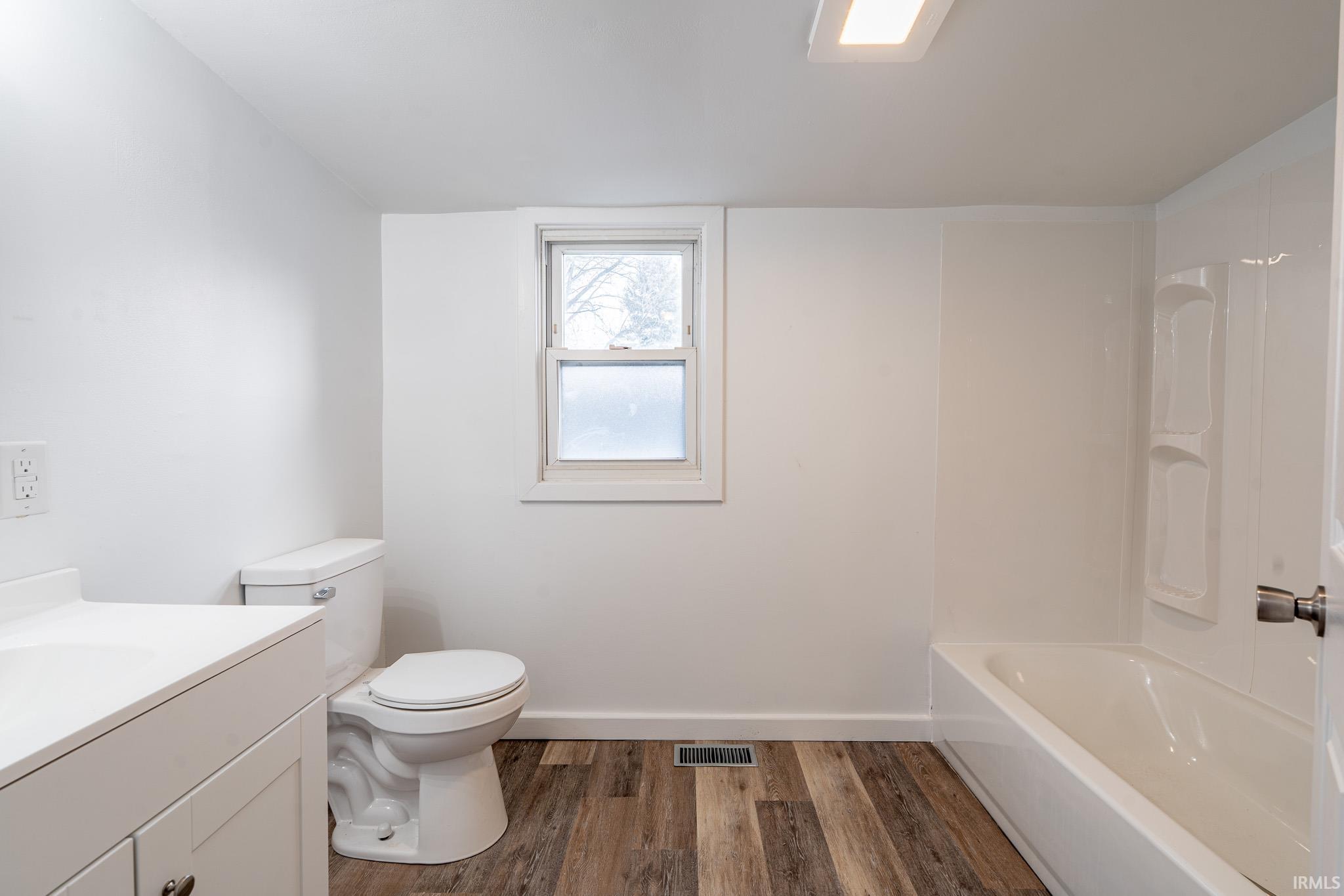 Full bath featuring vanity, dark wood-style floors, and bathing tub / shower combination