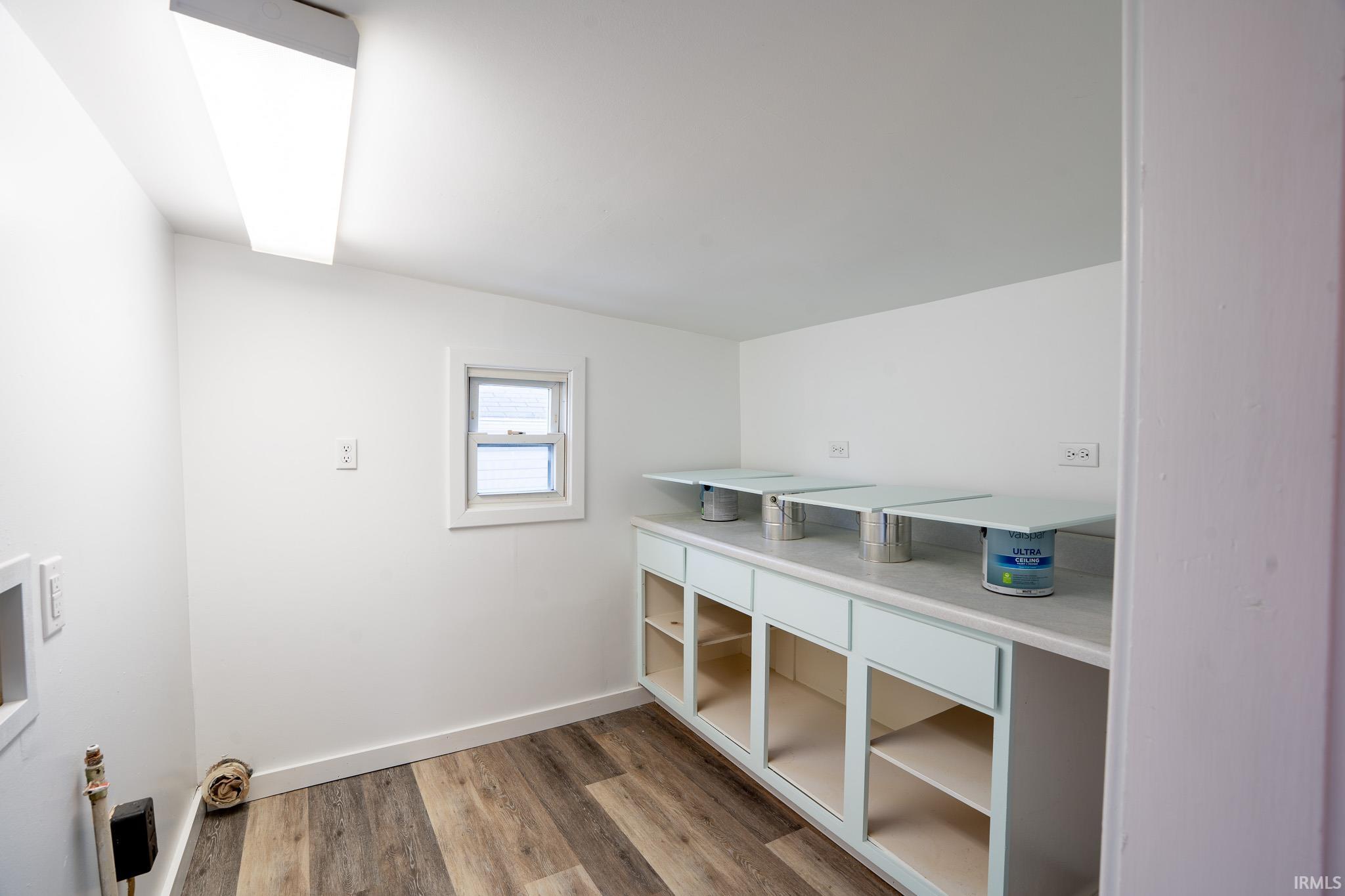 Laundry room featuring light wood-type flooring and baseboards