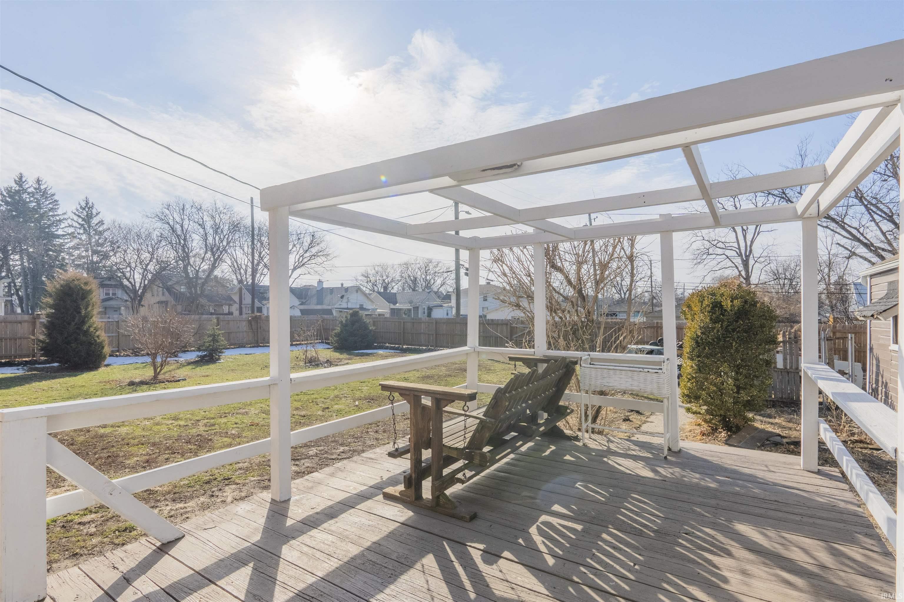 Wooden terrace with a residential view and a fenced backyard
