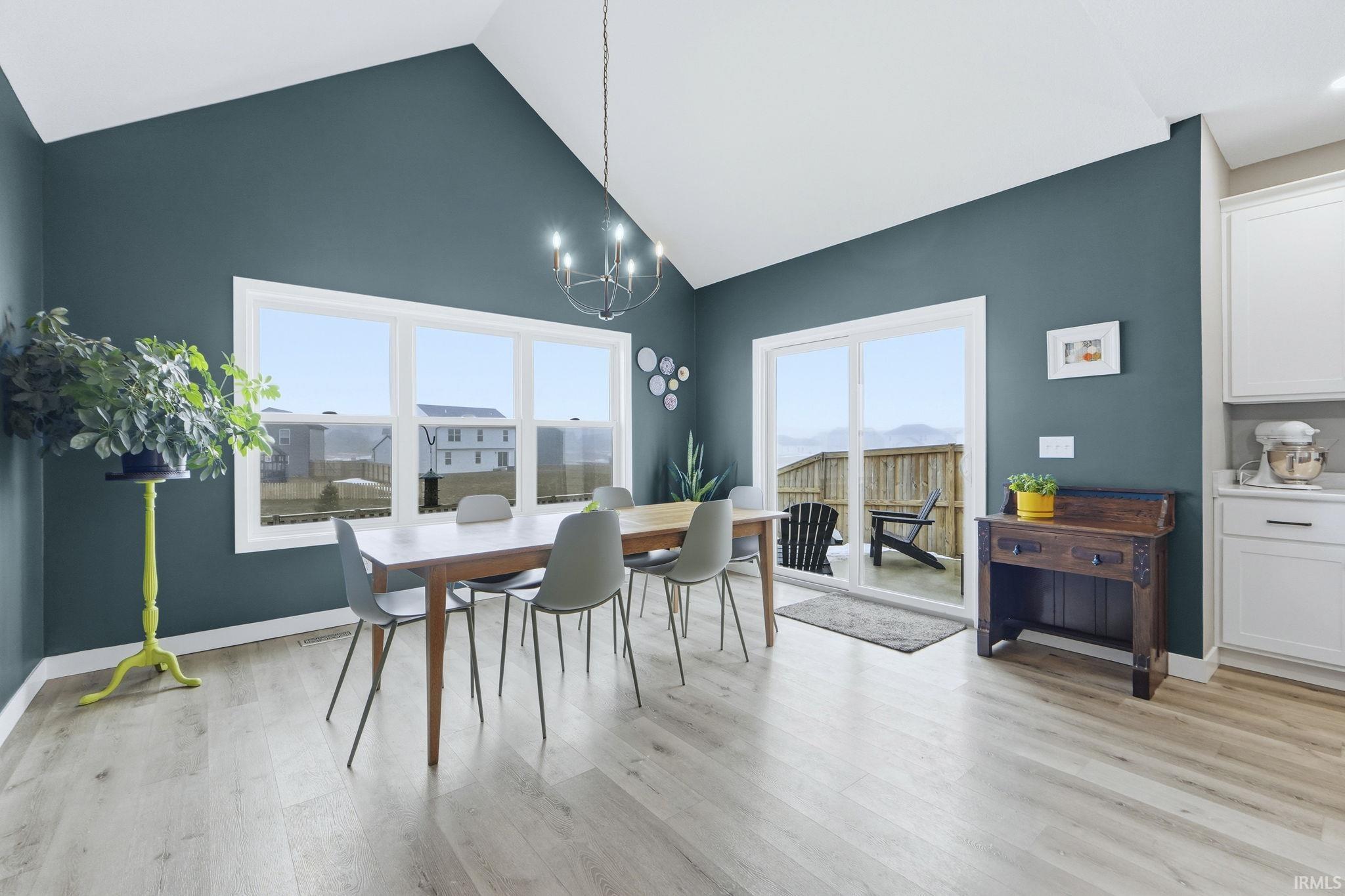Dining space featuring a chandelier, lofted ceiling, and light wood finished floors