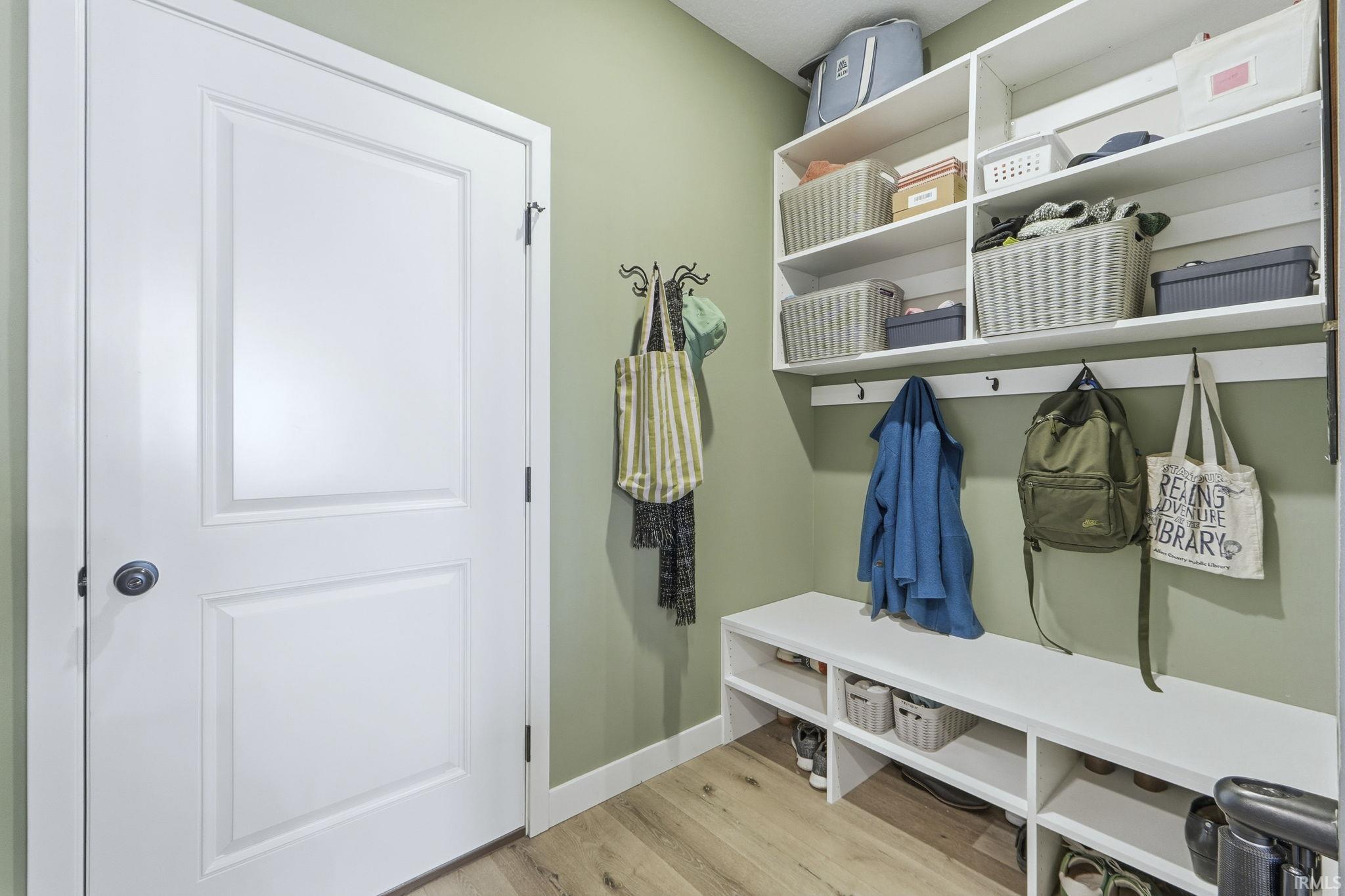 Mudroom featuring light wood finished floors and baseboards
