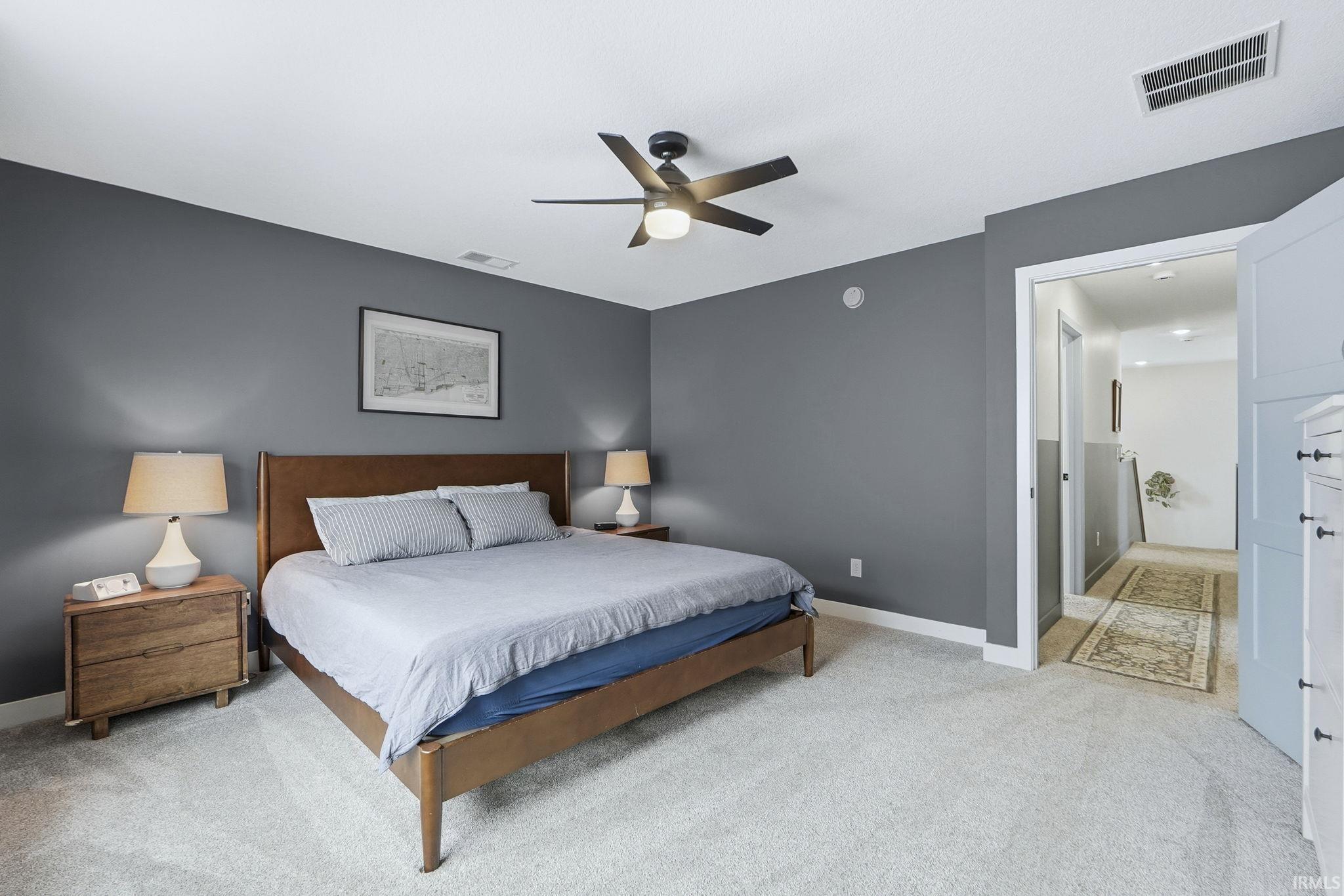 Bedroom with light carpet and a ceiling fan