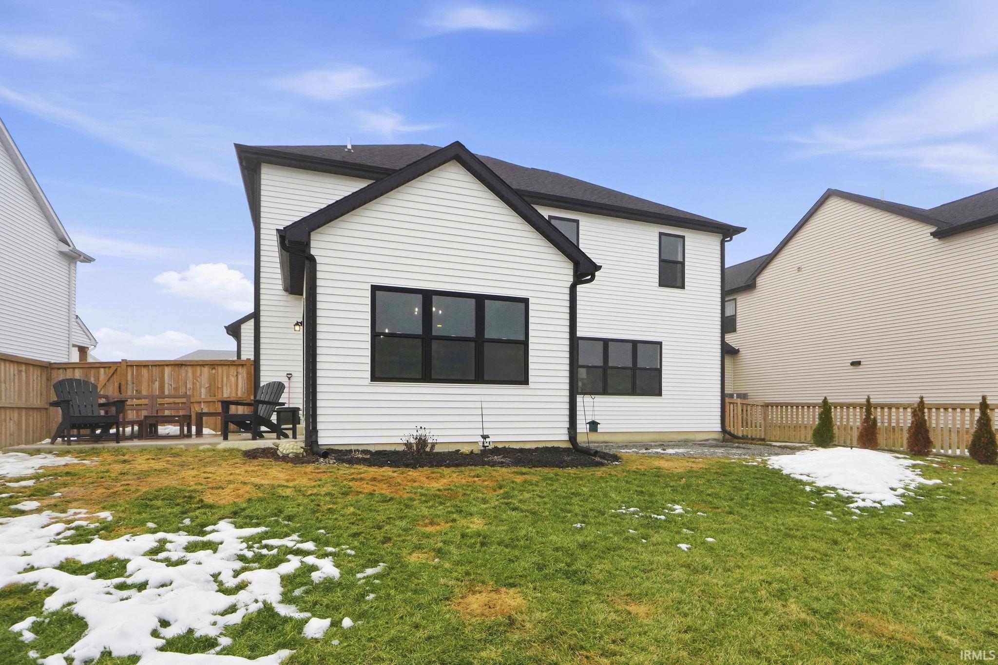 Snow covered property with a fenced backyard and a patio area